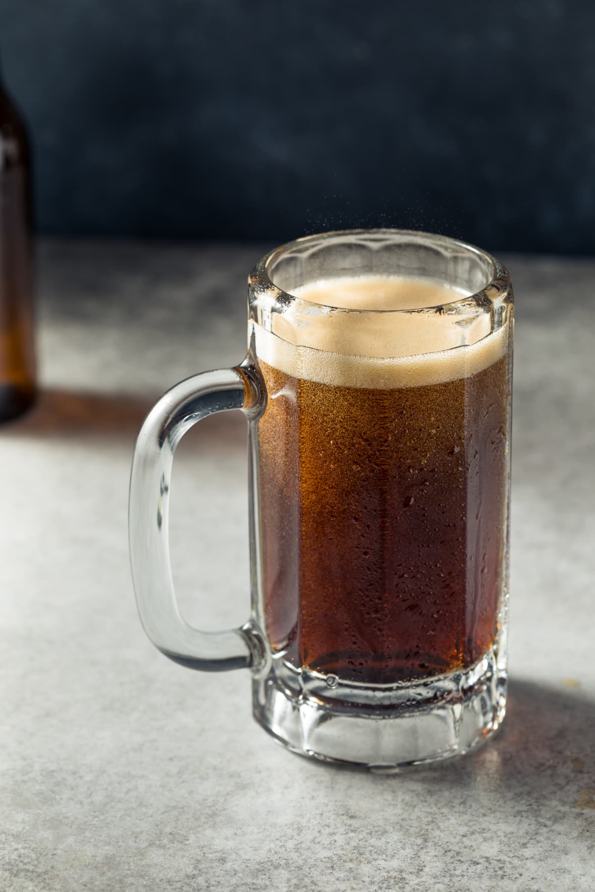 Root beer in a glass on a gray surface