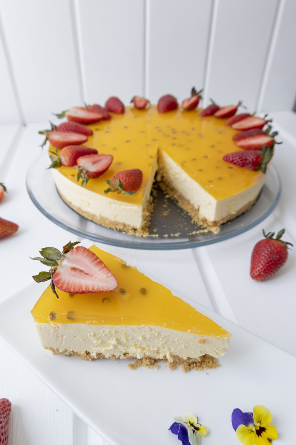 Passionfruit cheesecake, top view on white grunge timber.  With fresh fruit.