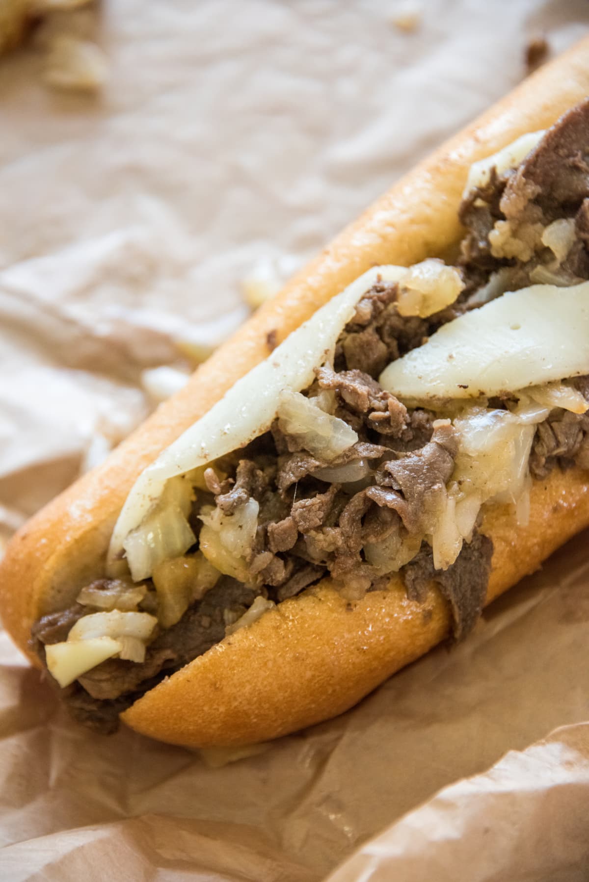Close up of a Philadelphia cheesesteak whiz wit sandwich, with onions and Whiz cheese