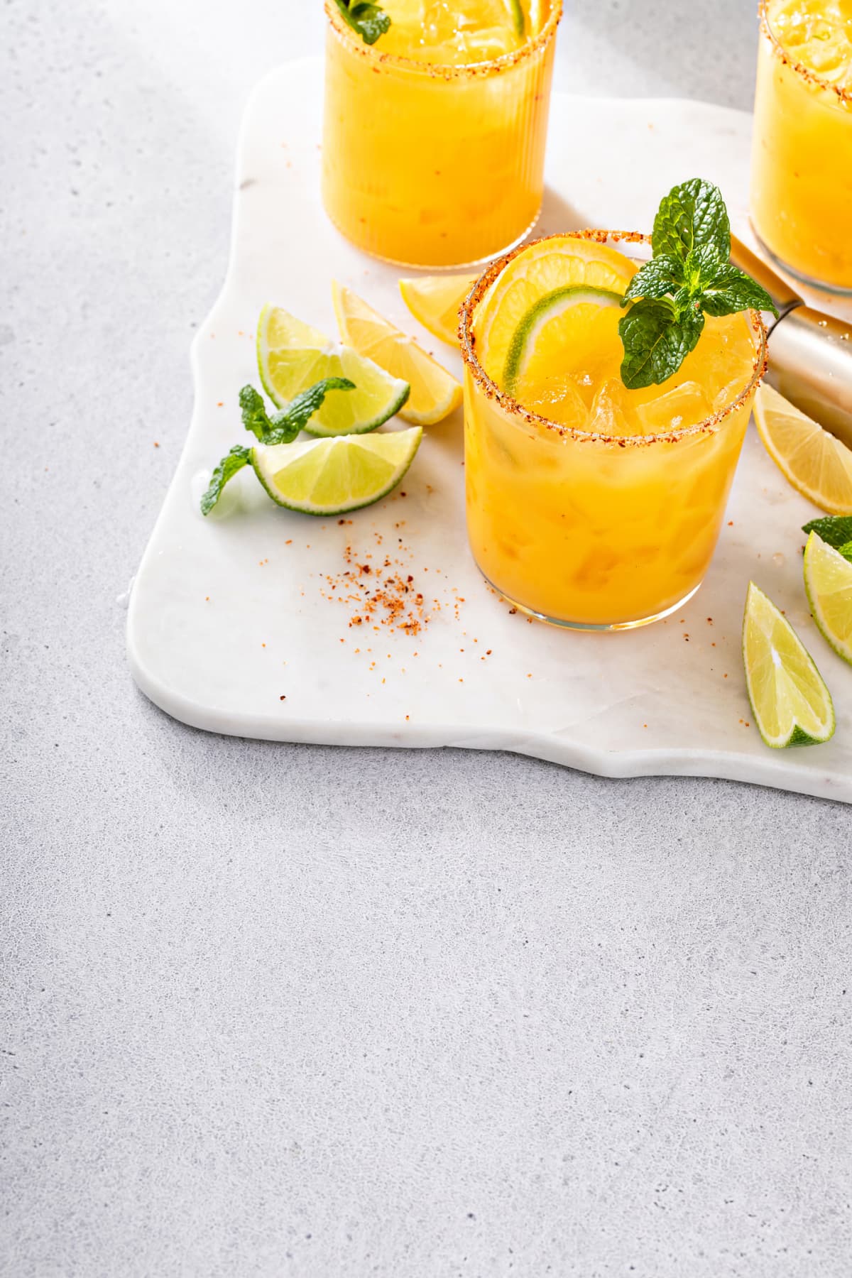 Triple citrus margarita with orange, lemon and lime garnished with mint with copy space