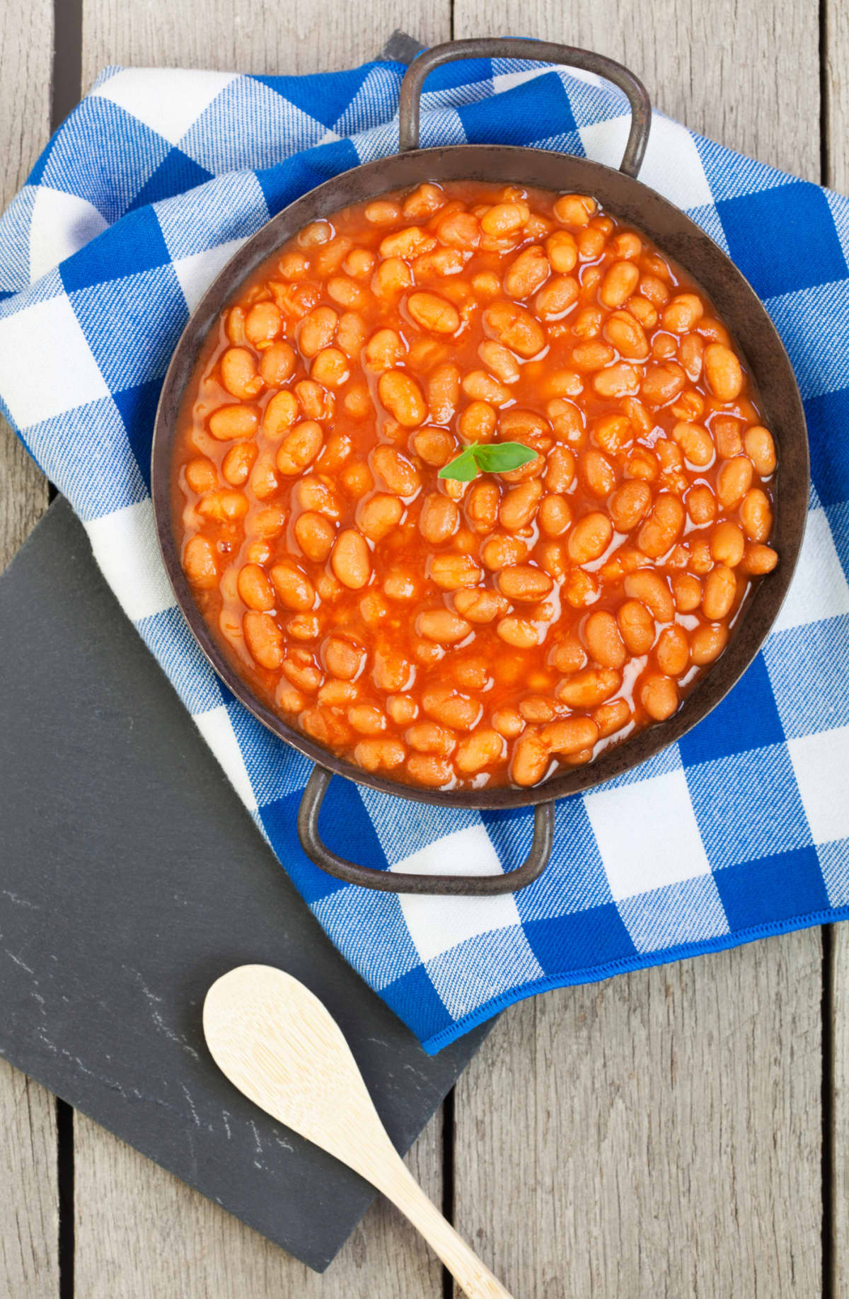 Classic baked beans in a rustic antique pan.