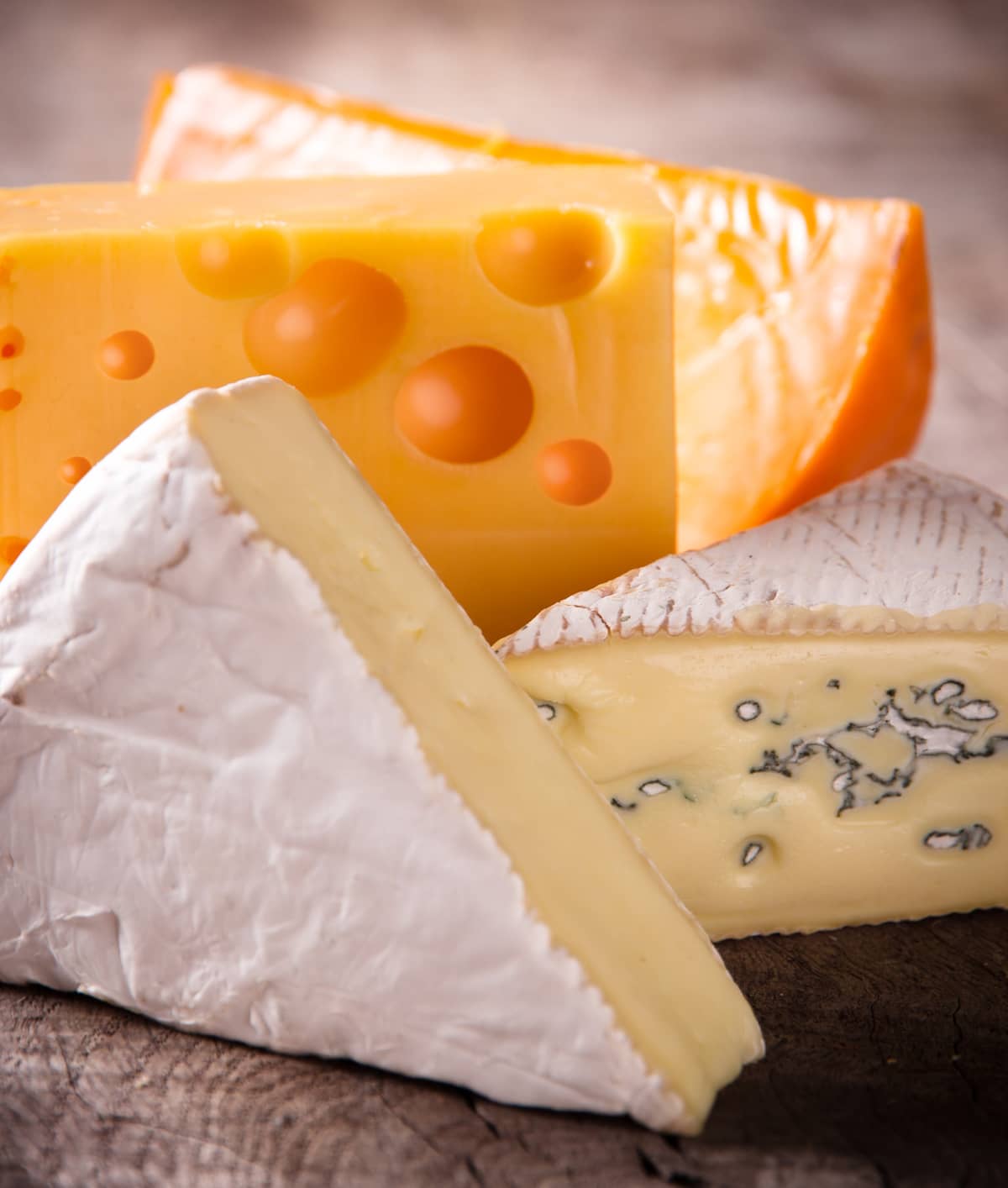 Various types of cheese on a wooden surface