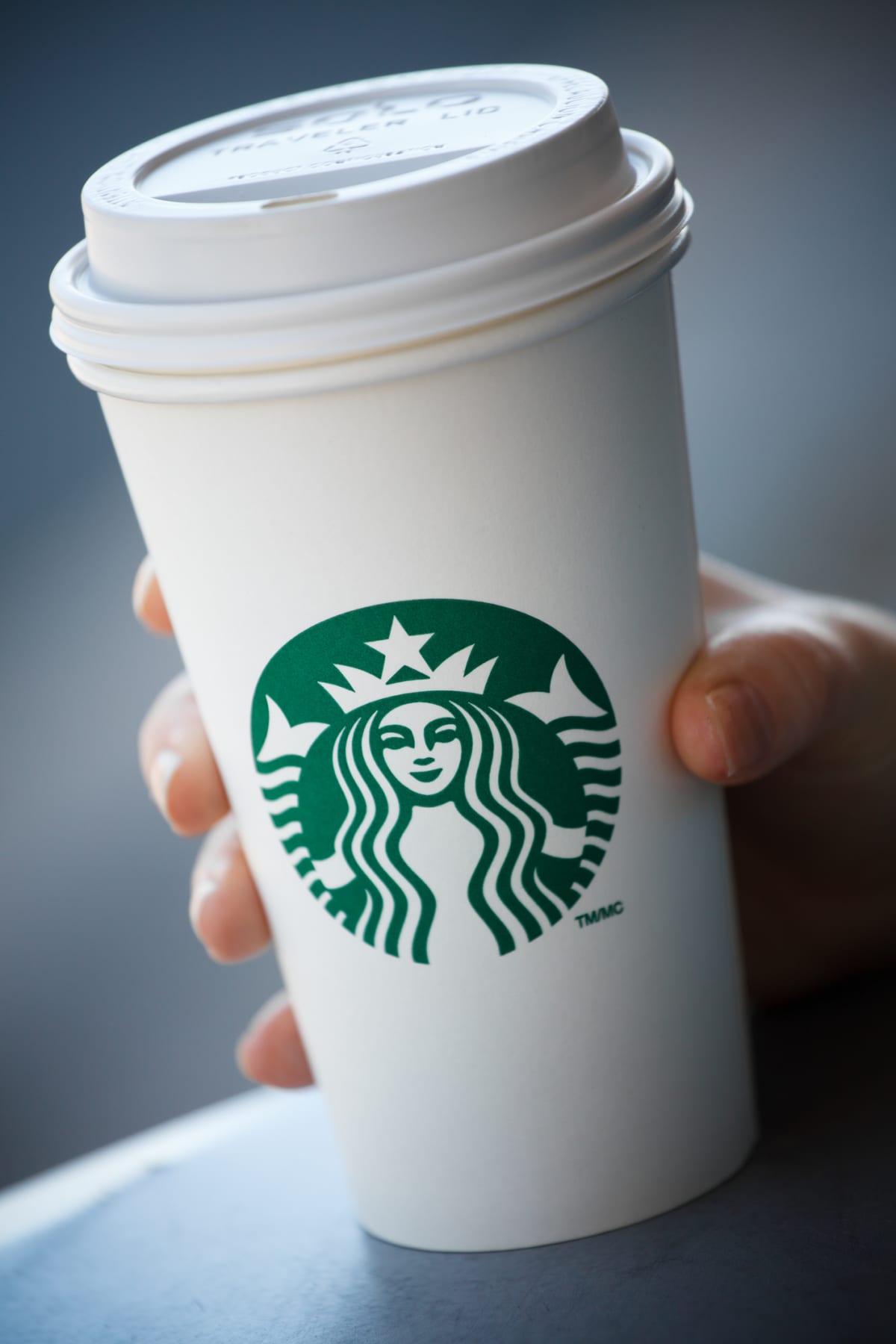 Hand holding a Starbucks coffee cup