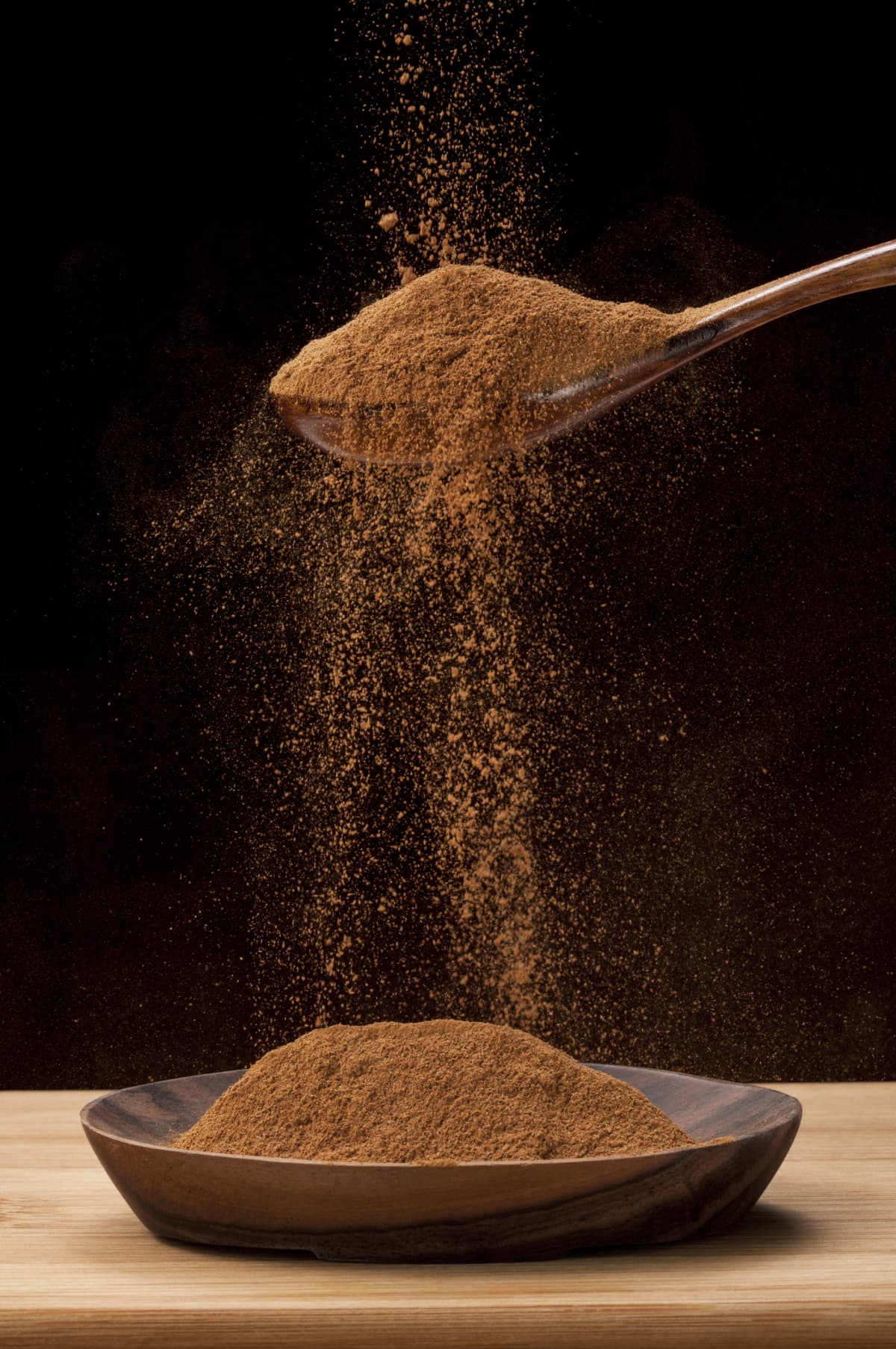 Cinnamon being sprinkled from a spoon.