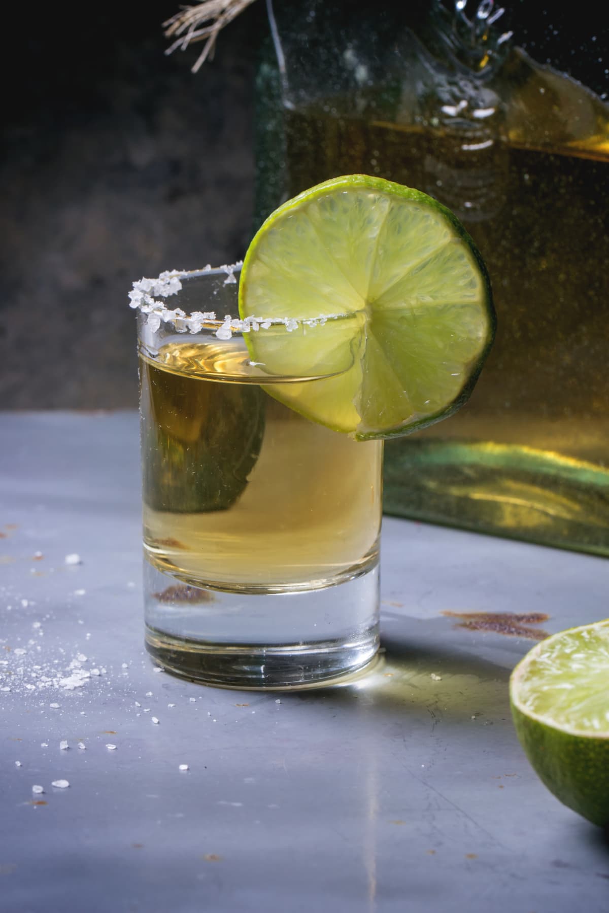 Glass of tequila with salted rim and lime
