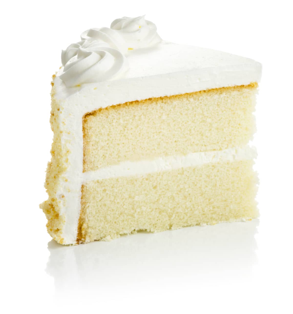 Slice of layered vanilla cake with vanilla icing. 