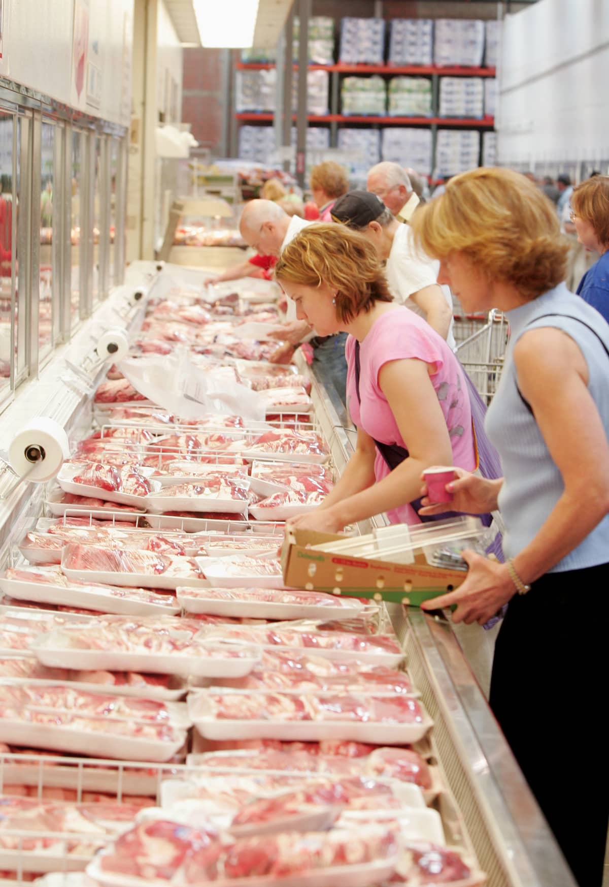 Costumers looking at meat display in Costco store 