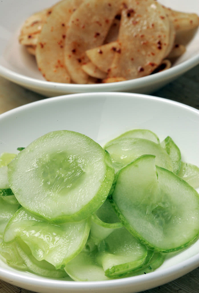 Pickled cucumber and daikon radish in white bowls