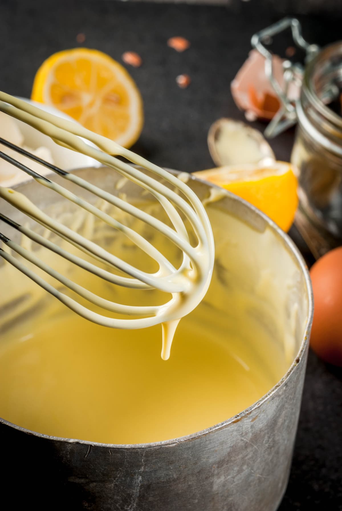 A bowl of hollandaise sauce and a whisk