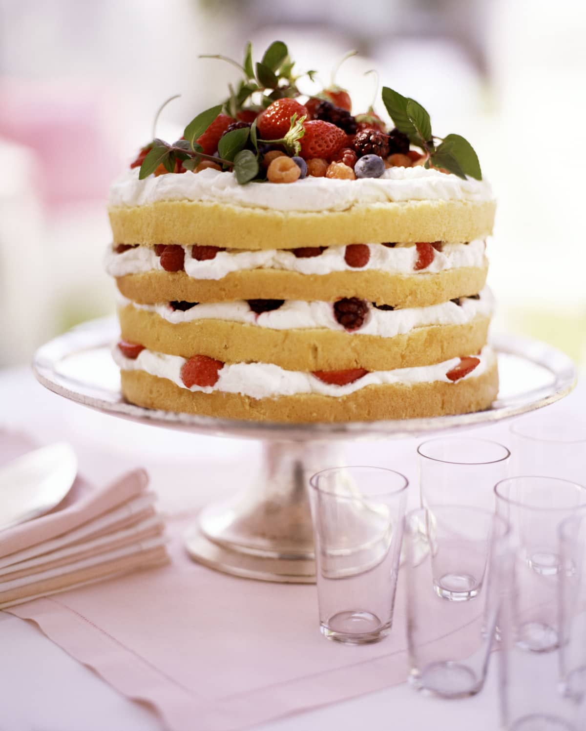 Berry shortcake on a white stand with green garnish