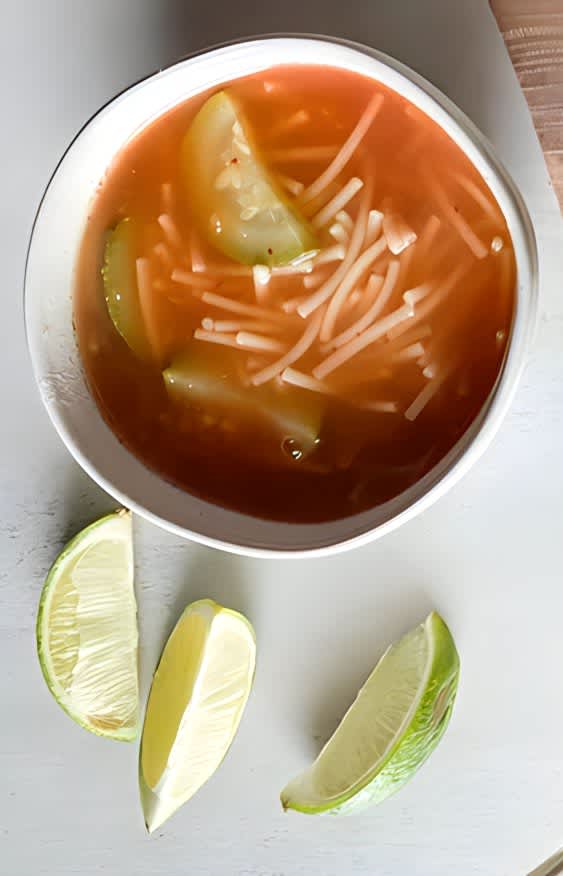 Mexican tomato noodle soup with limes