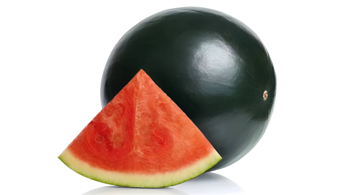 Whole Densuke watermelon next to slice of melon