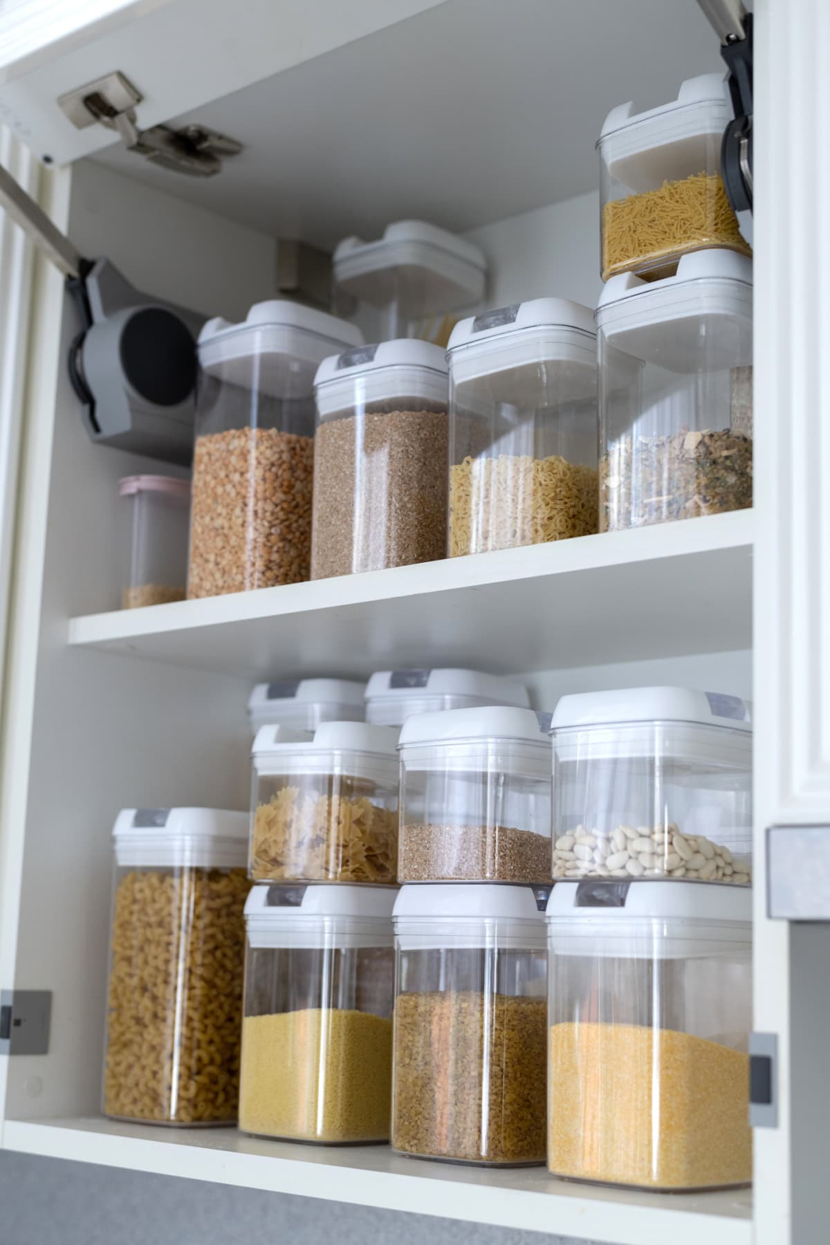 Food storage containers filled with cereals in the kitchen pantry