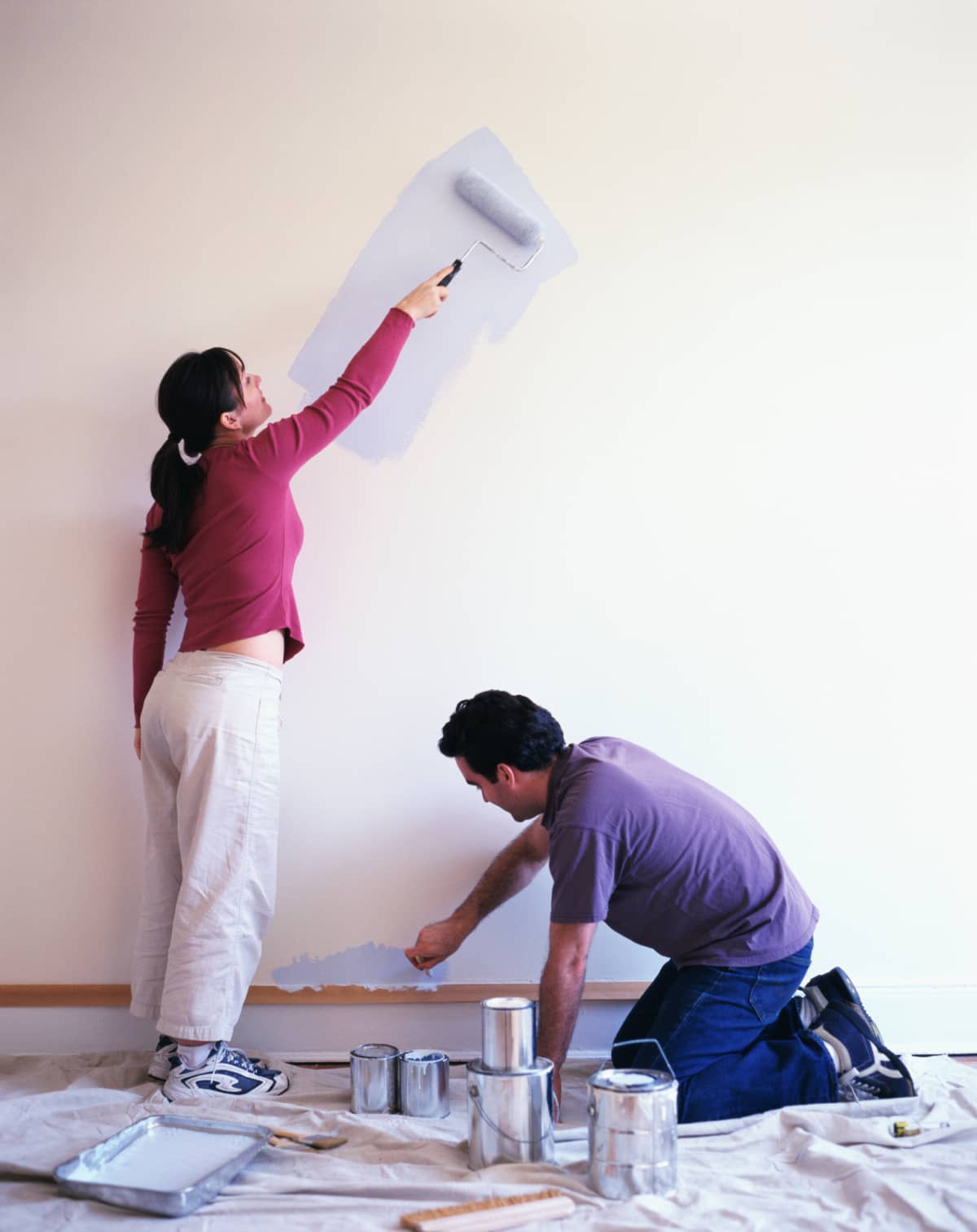 Couple painting a wall blue