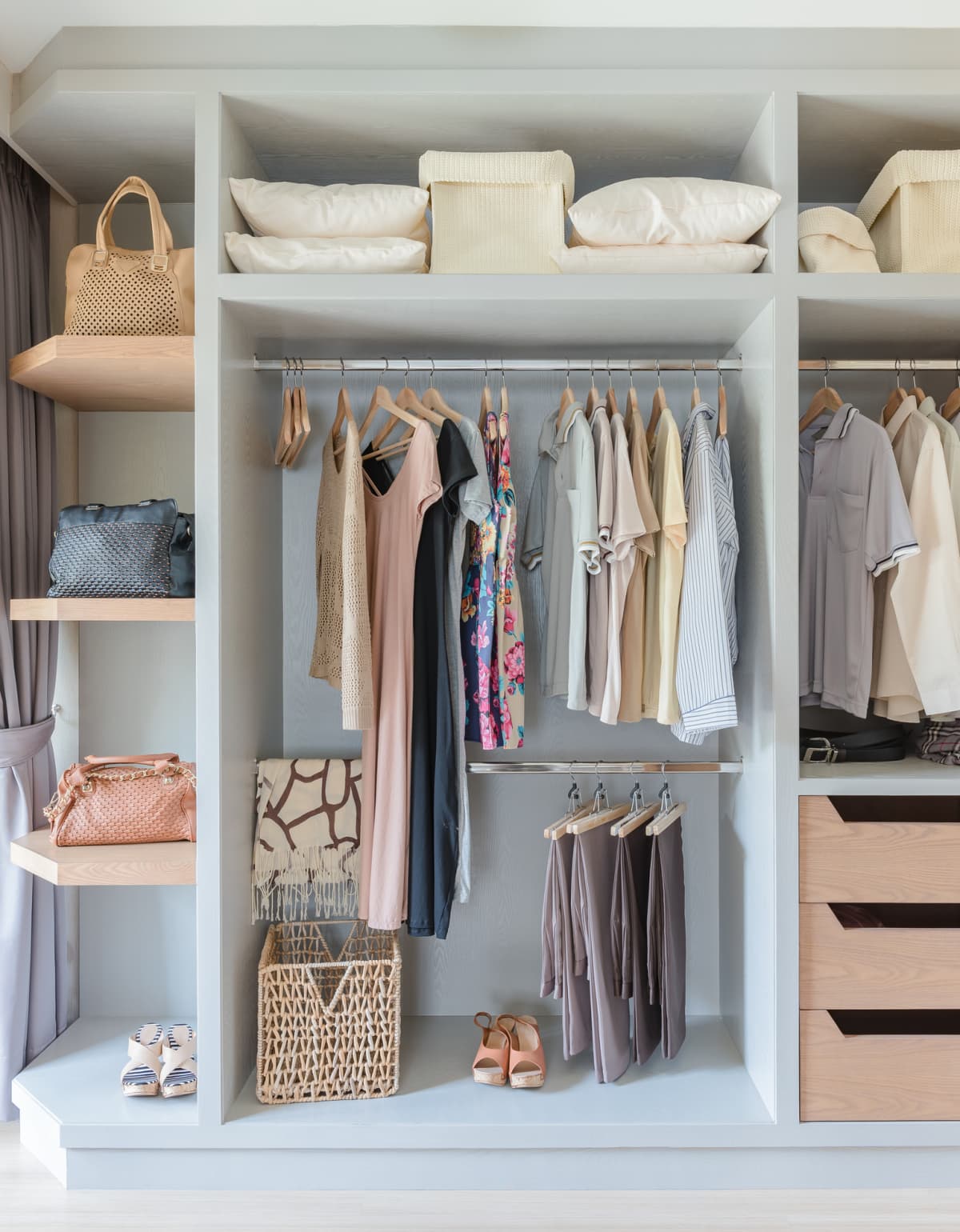 white wardrobe with shirts and pants hanging on rail