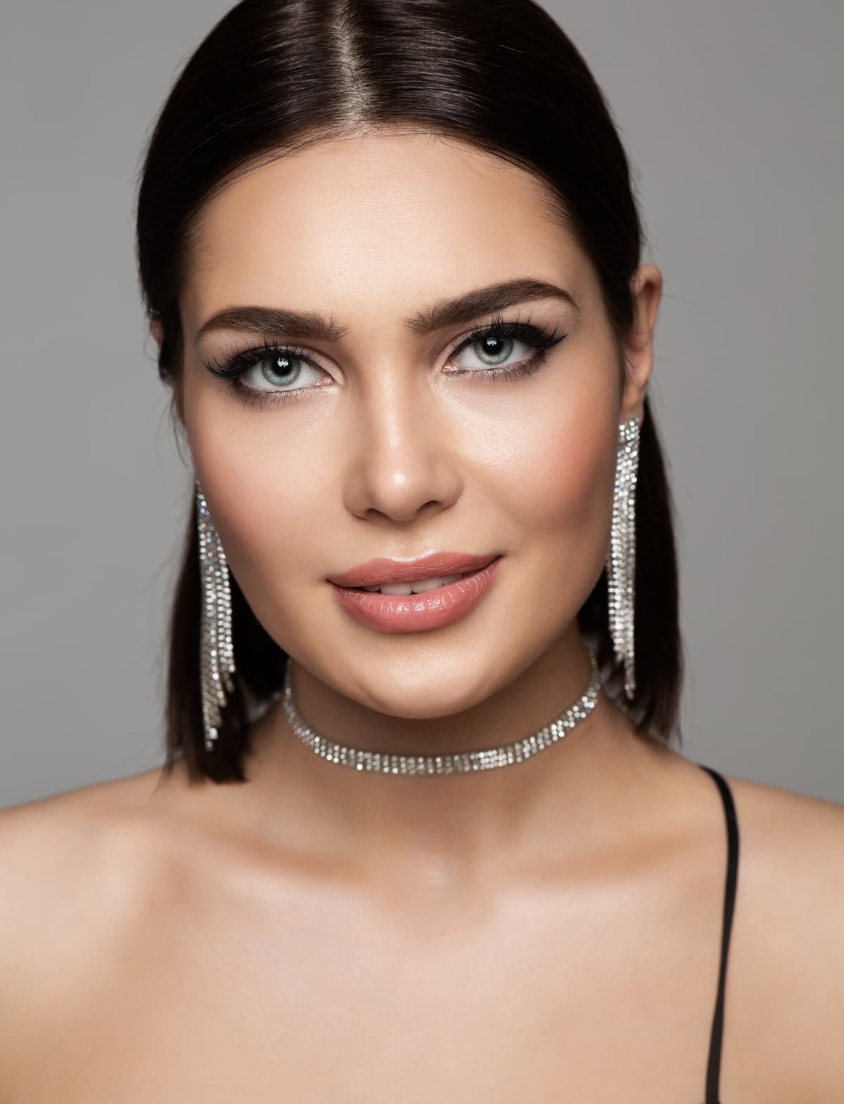 Closeup of a woman wearing silver earrings and necklace
