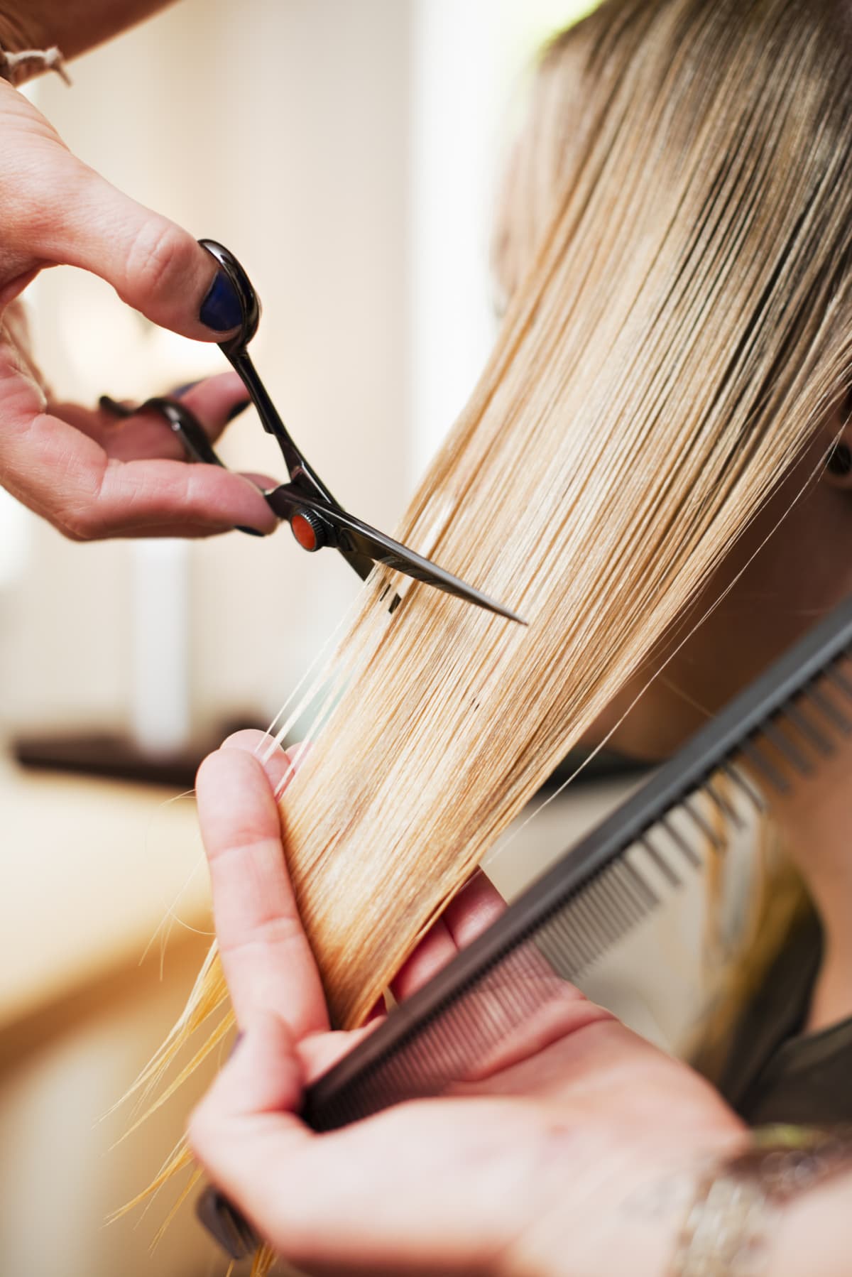 A woman with long hair at a hair salon getting a haircut