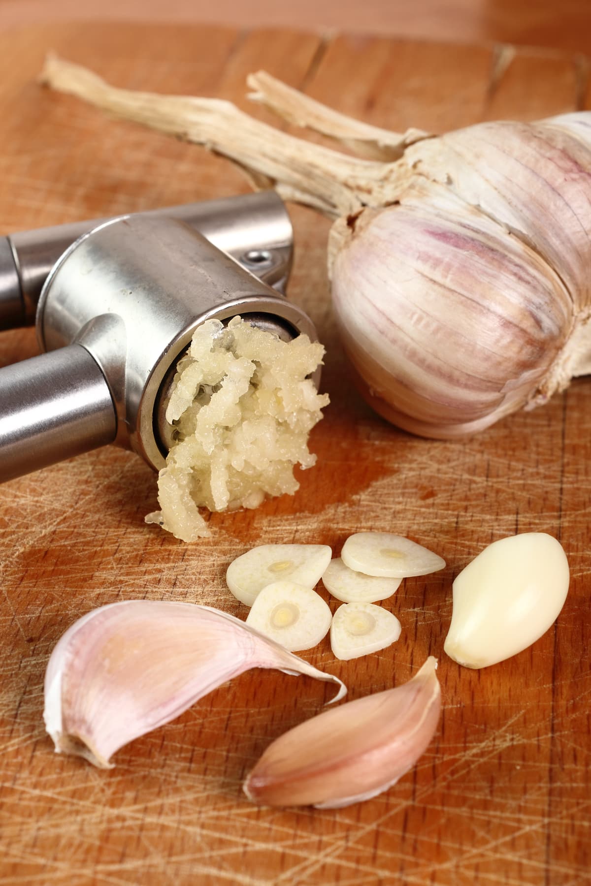 Sliced, crushed garlic and garlic press