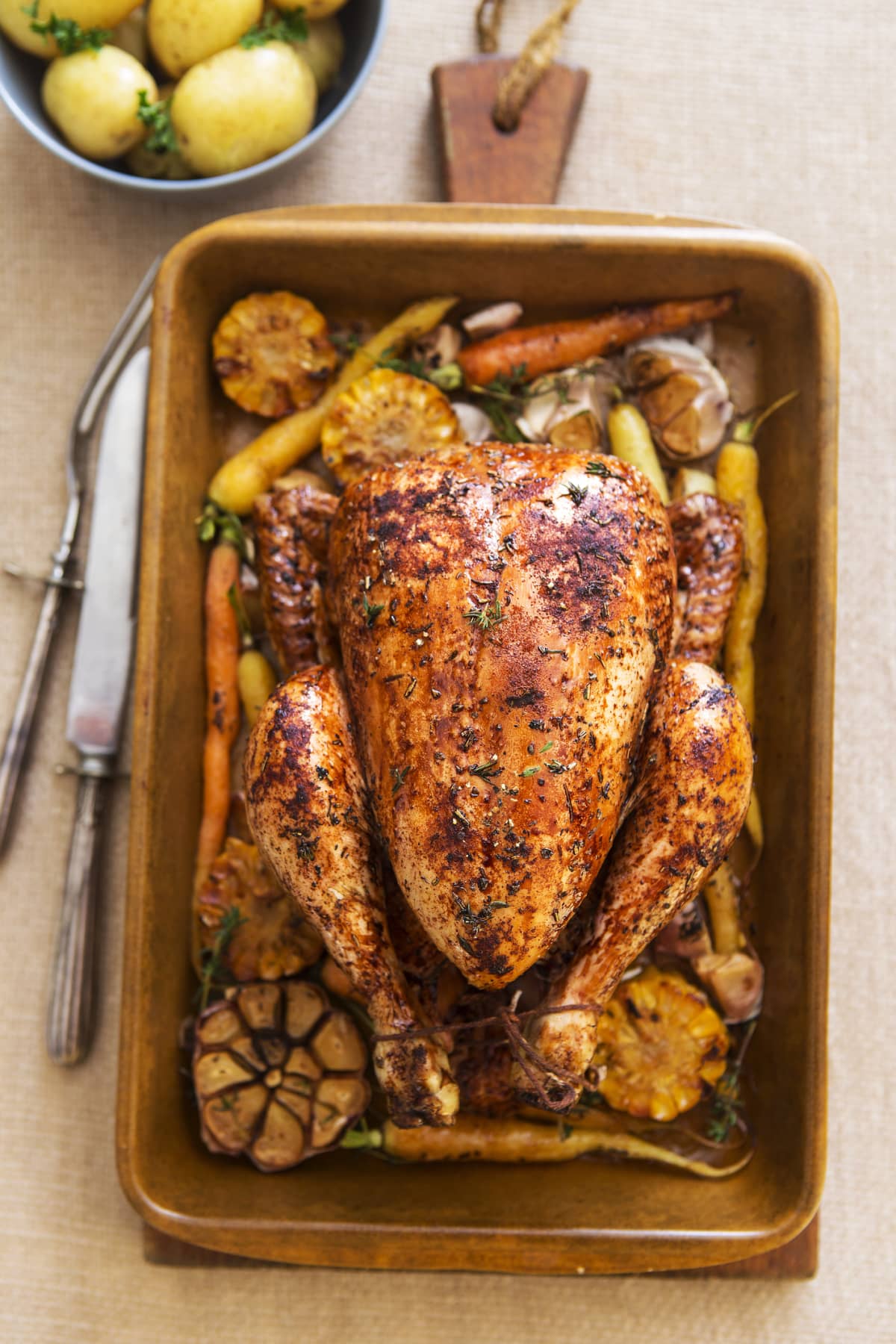 Roasted whole chicken in pan with carrots and mushroom