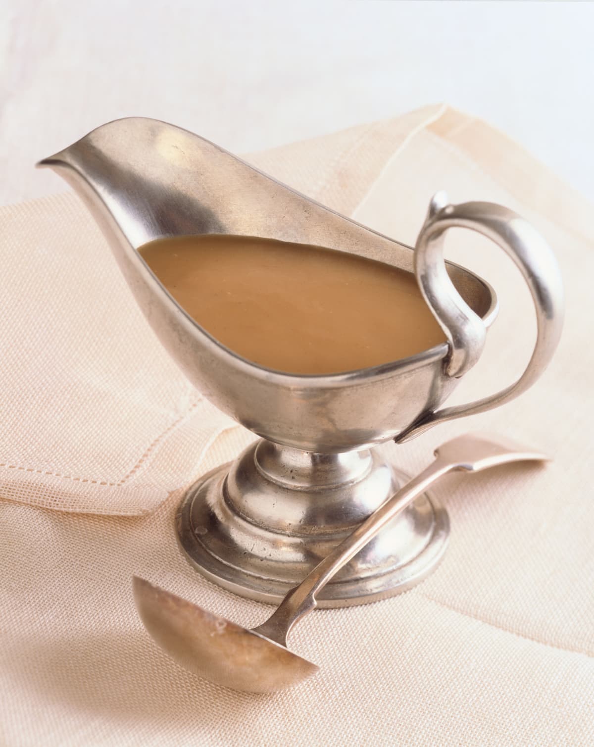 Gravy boat on cloth with a ladle