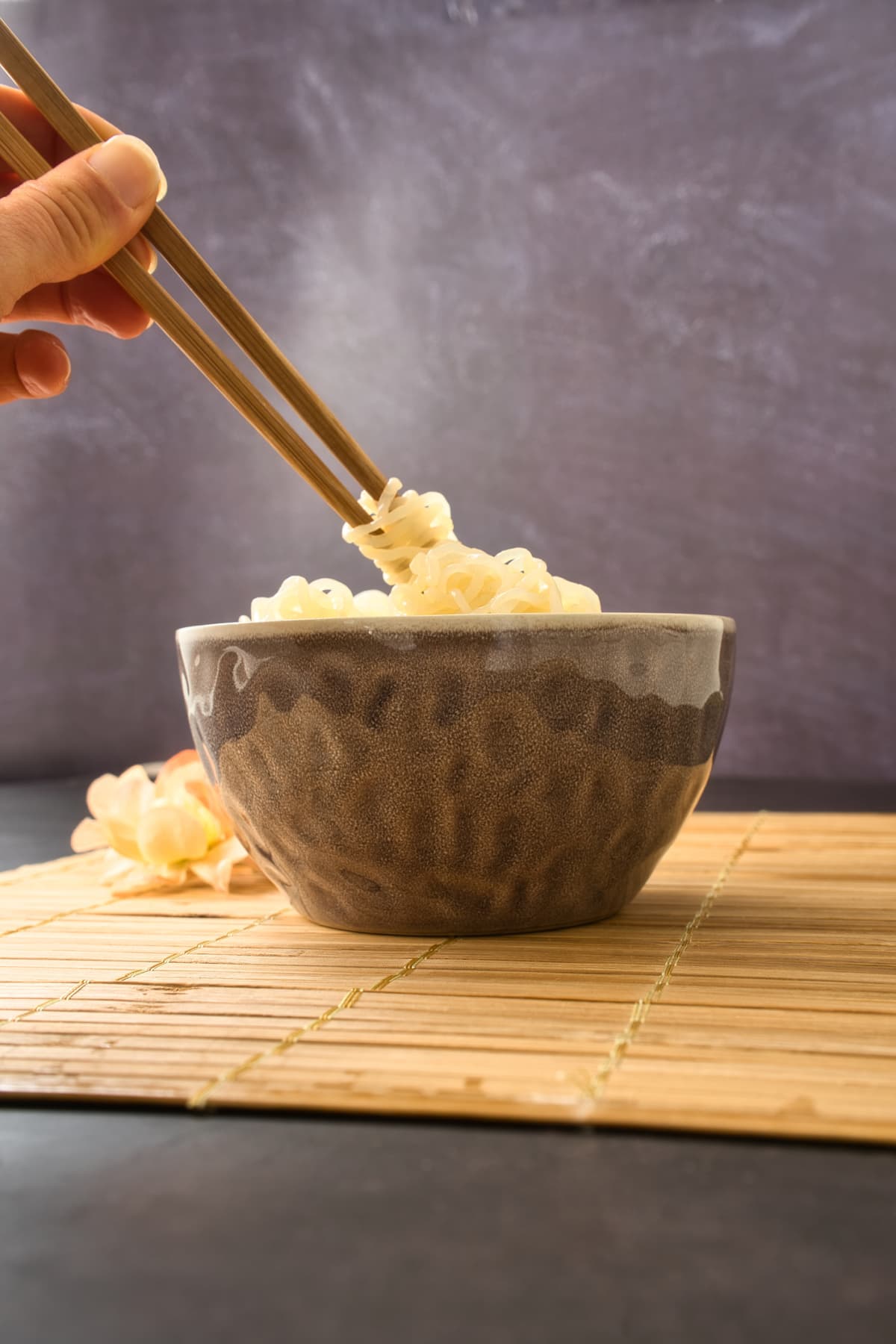 shirataki konjac noodles tagliatelle in a bowl, with chopsticks