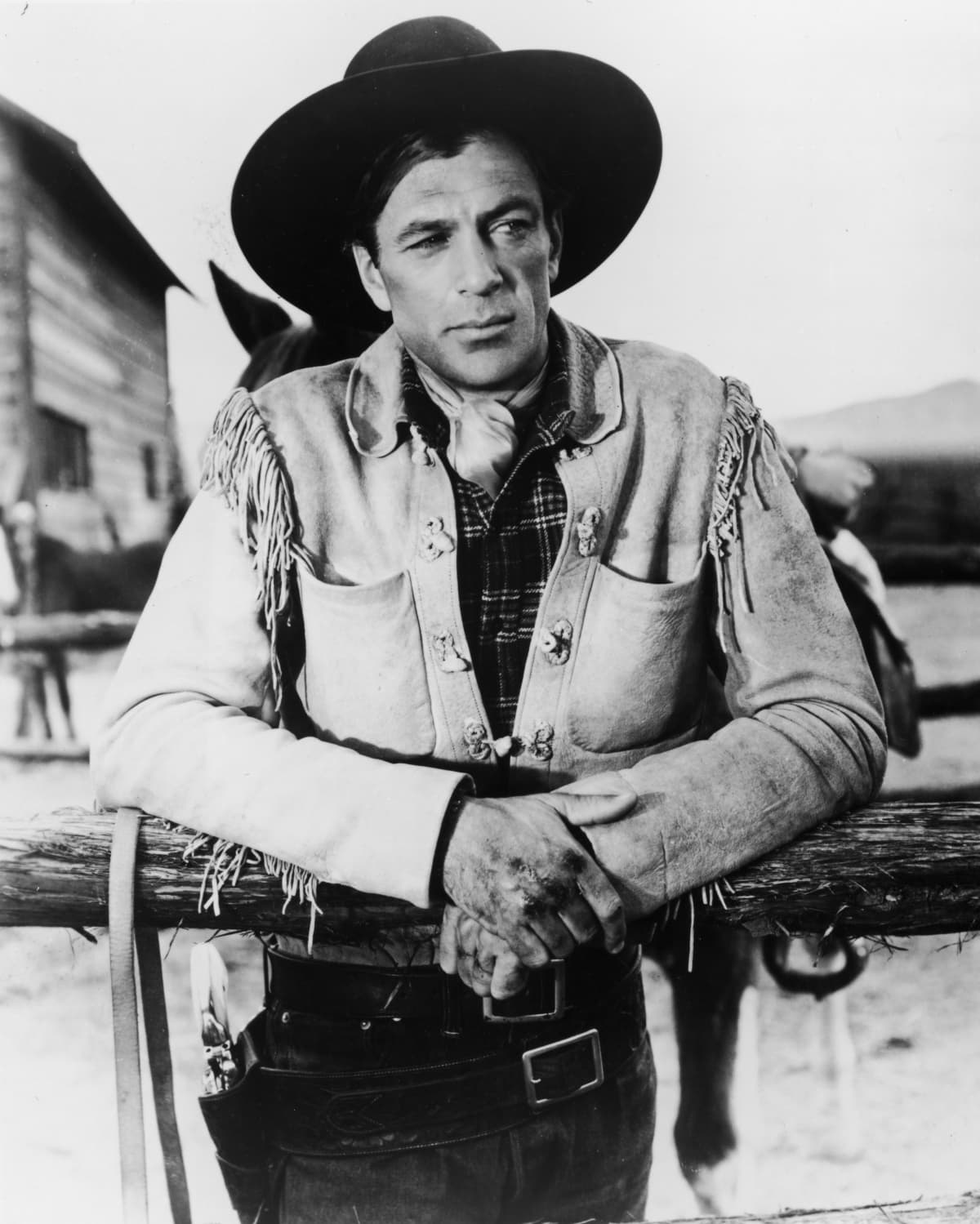 American actor Gary Cooper (1901 - 1961), dressed in a fringed jacket and cowboy hat with a gun belt and holster around his waist, in a publicity still for the film 'Fighting Caravans', 1931. (Photo by Hulton Archive/Getty Images)