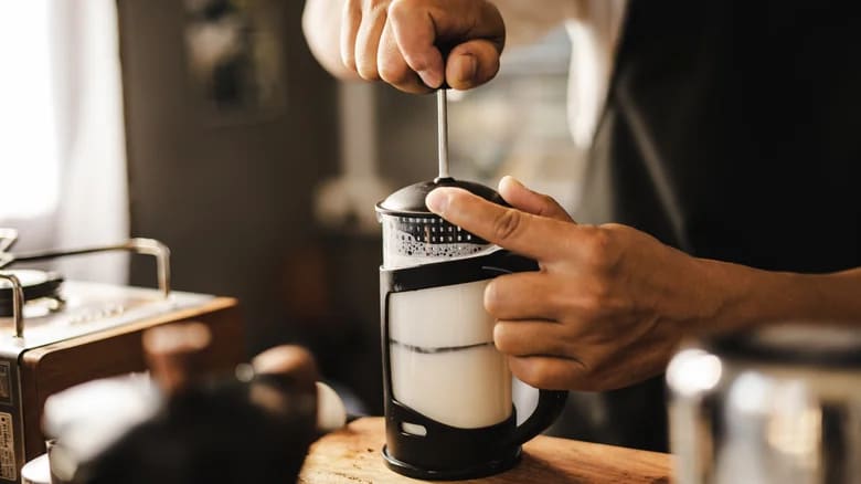 A person frothing milk with a milk frother