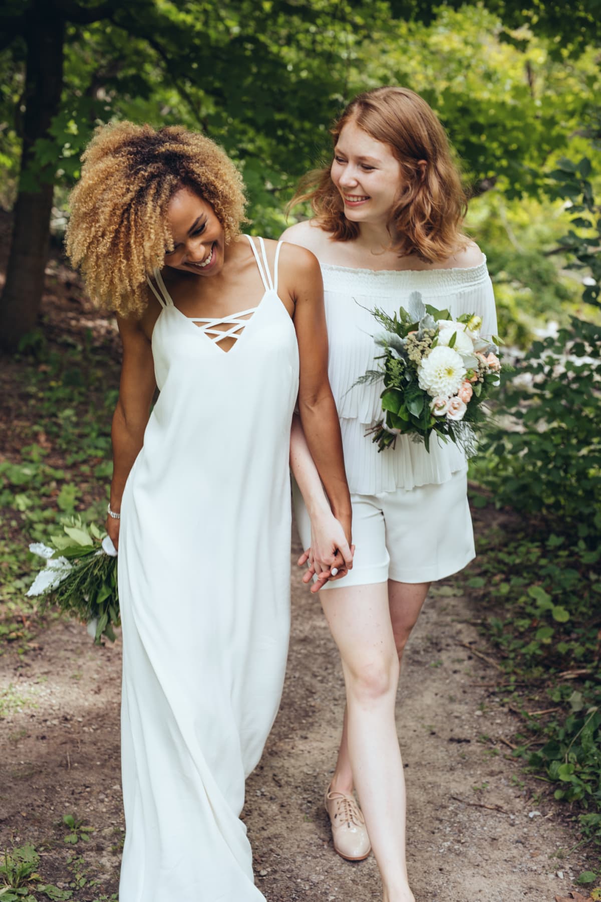 Two women wearing white wedding dresses as they elope