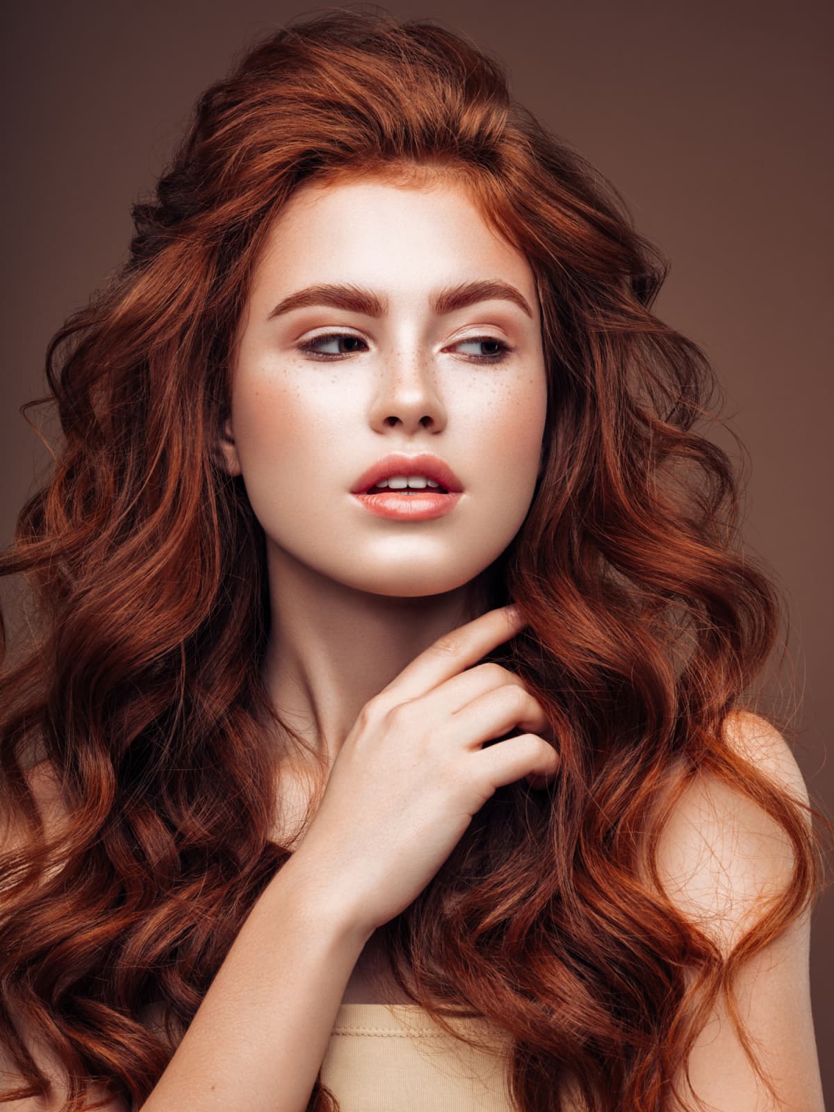 a woman with long, red, permed hair with tons of volume at the root
