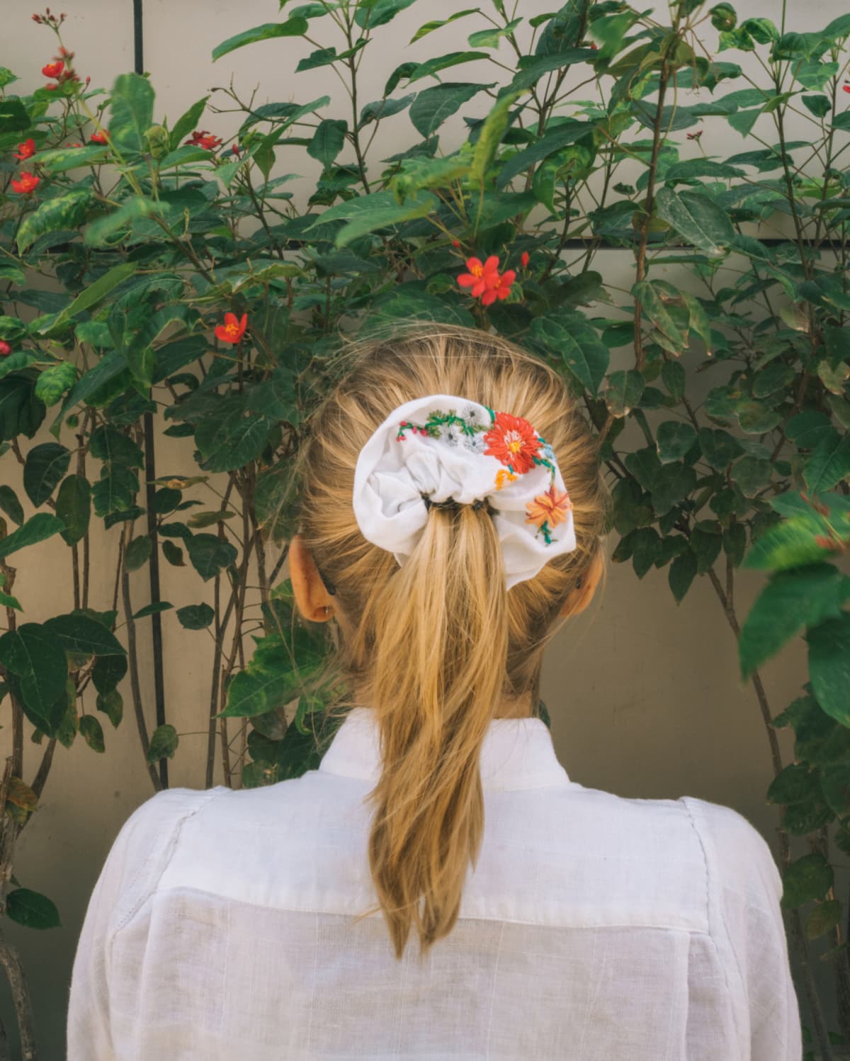 woman with her hair pulled half up with a jumbo scrunchie