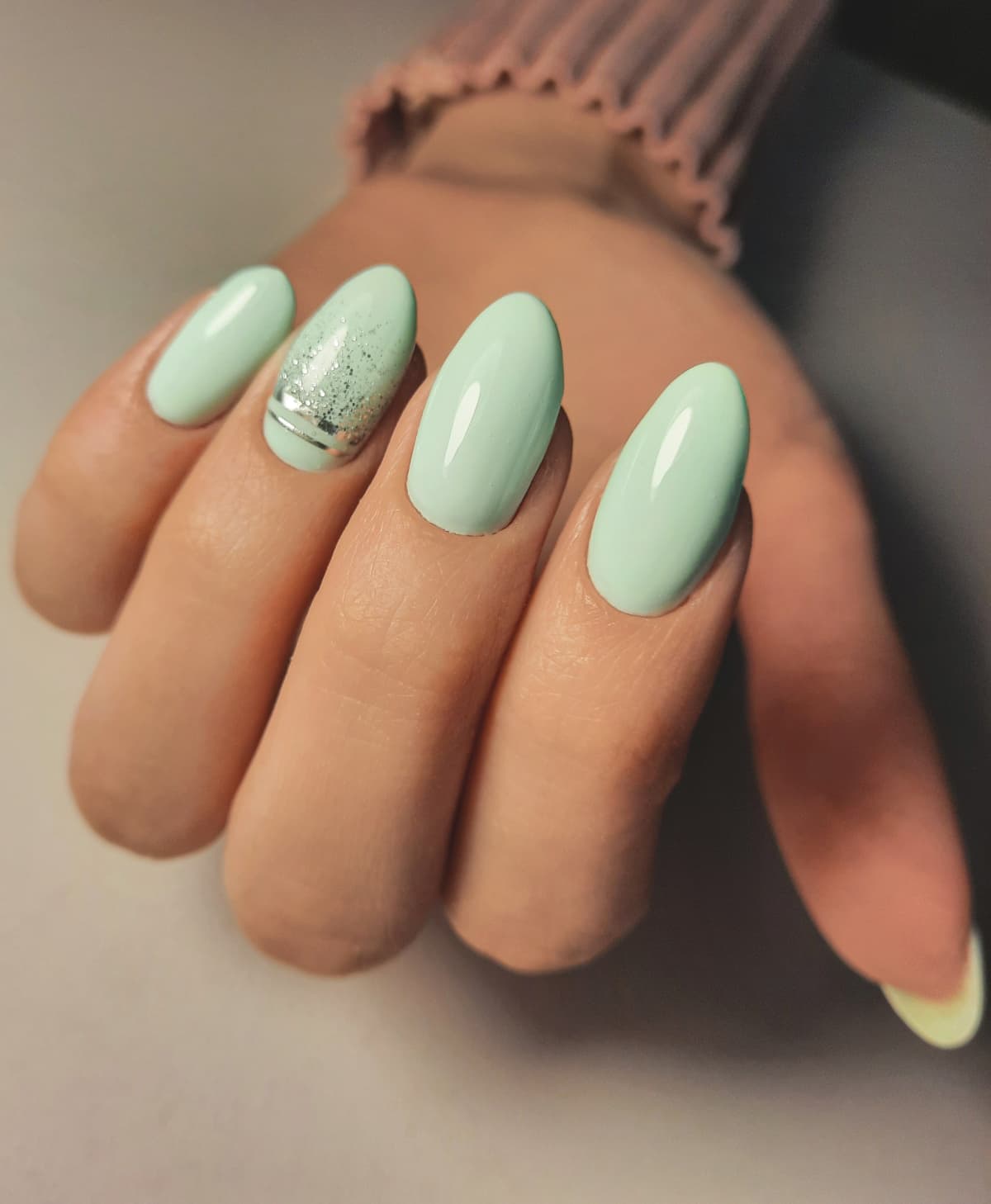 Hand with an almond-shaped manicure and nail art