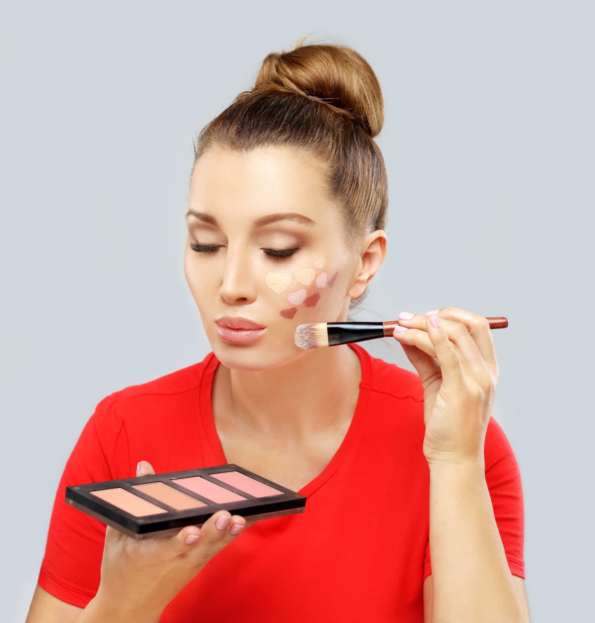 Woman with her eyes closed using contouring and highlighting makeup techniques