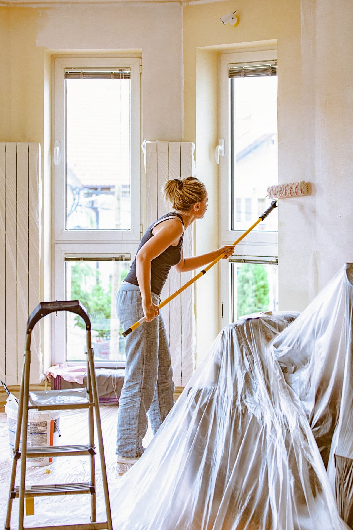 DIY home renovation work. Woman in casual wear. The shot is executed with available natural light, and the copy space has been left.