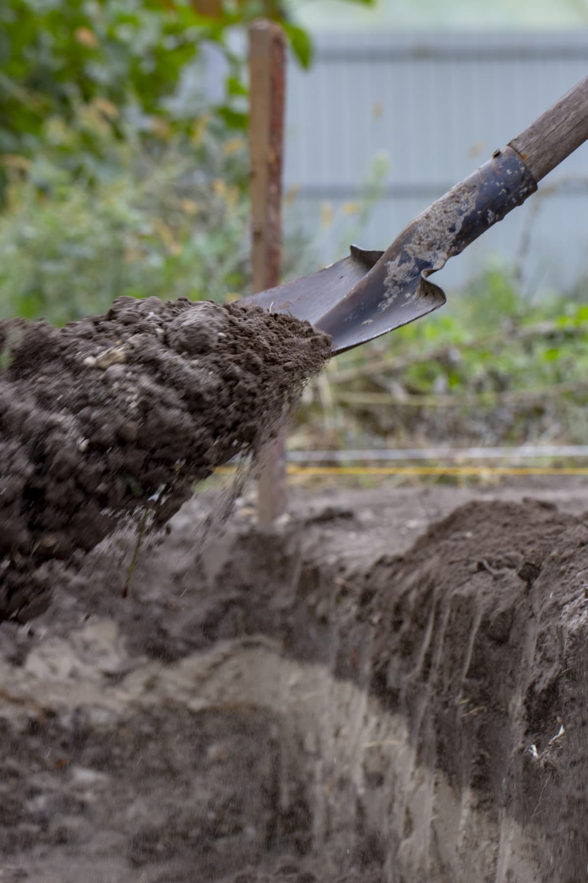 A person digging a hole in the ground with shovel