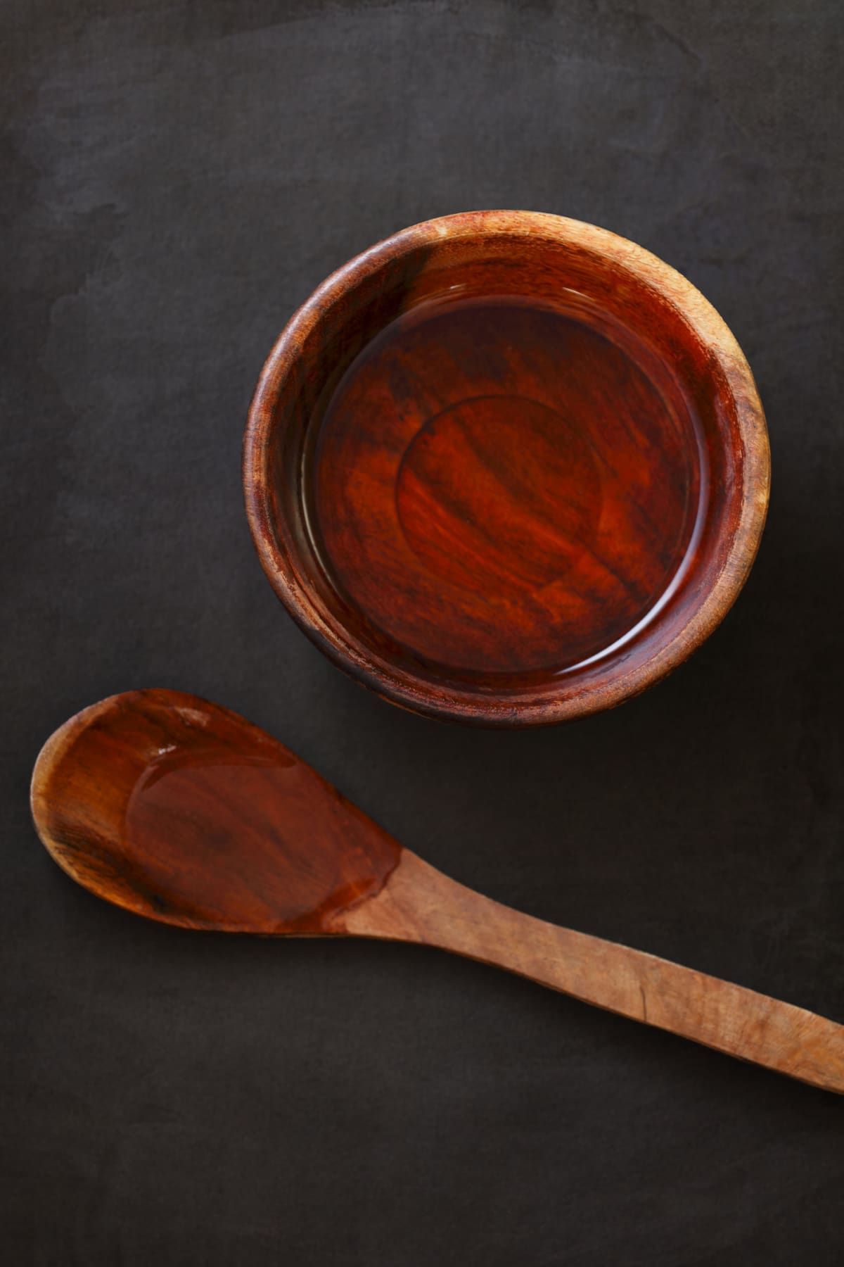 White vinegar in a wooden bowl and spoon