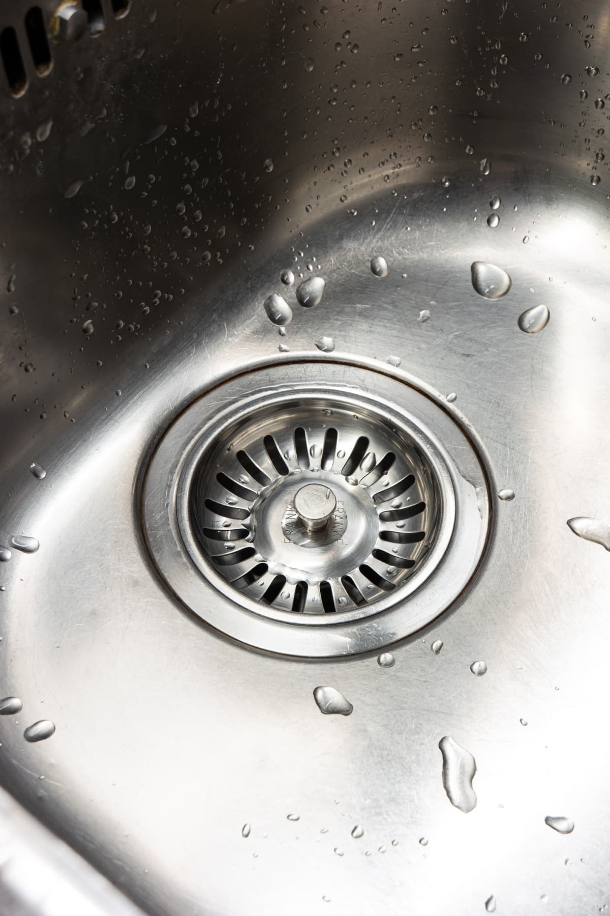 A clean stainless metal kitchen sink and drainage