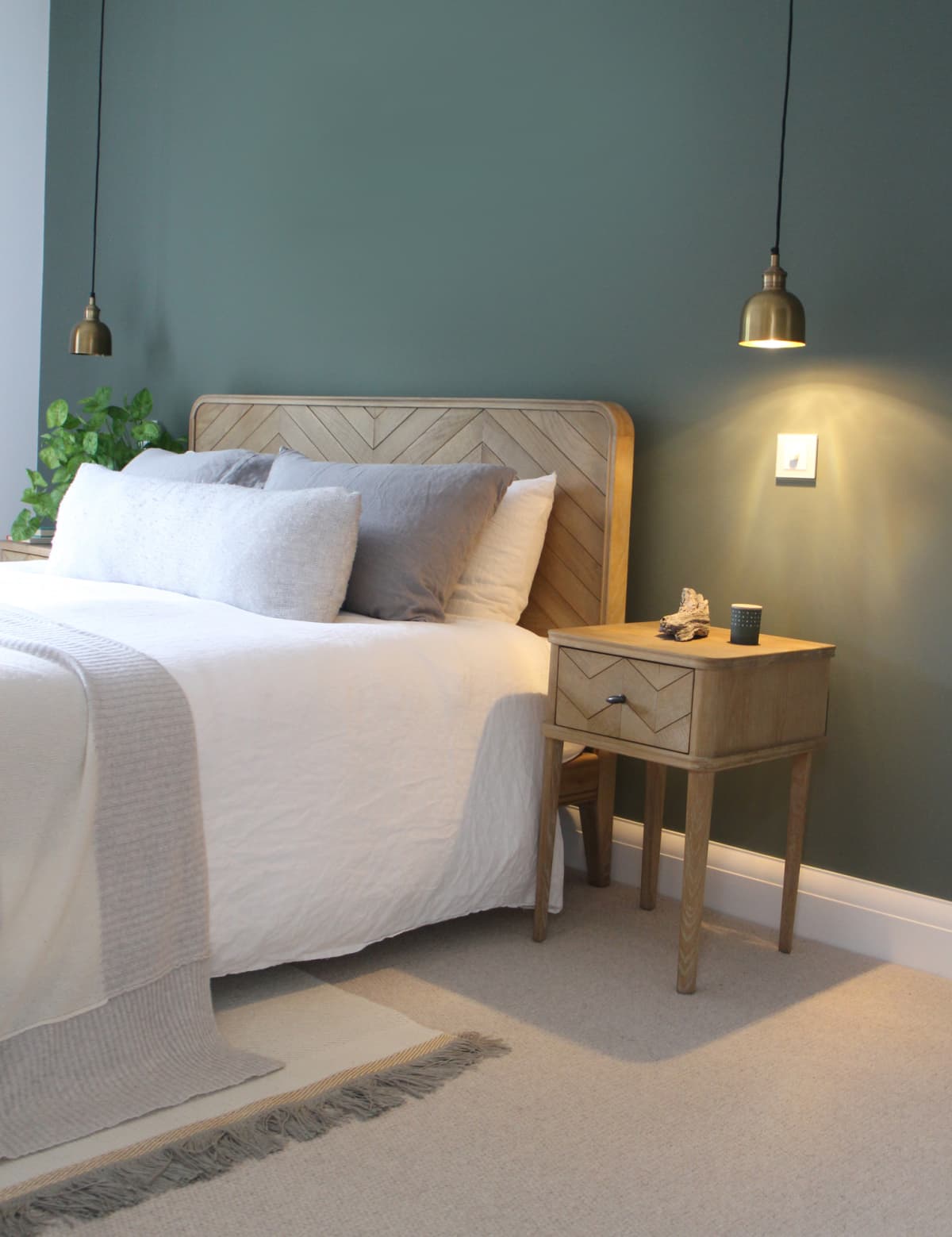 A bed with bedside table and lamp