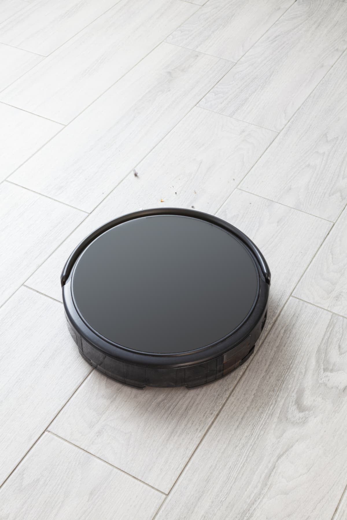 A black robot vacuum cleaner on a floor