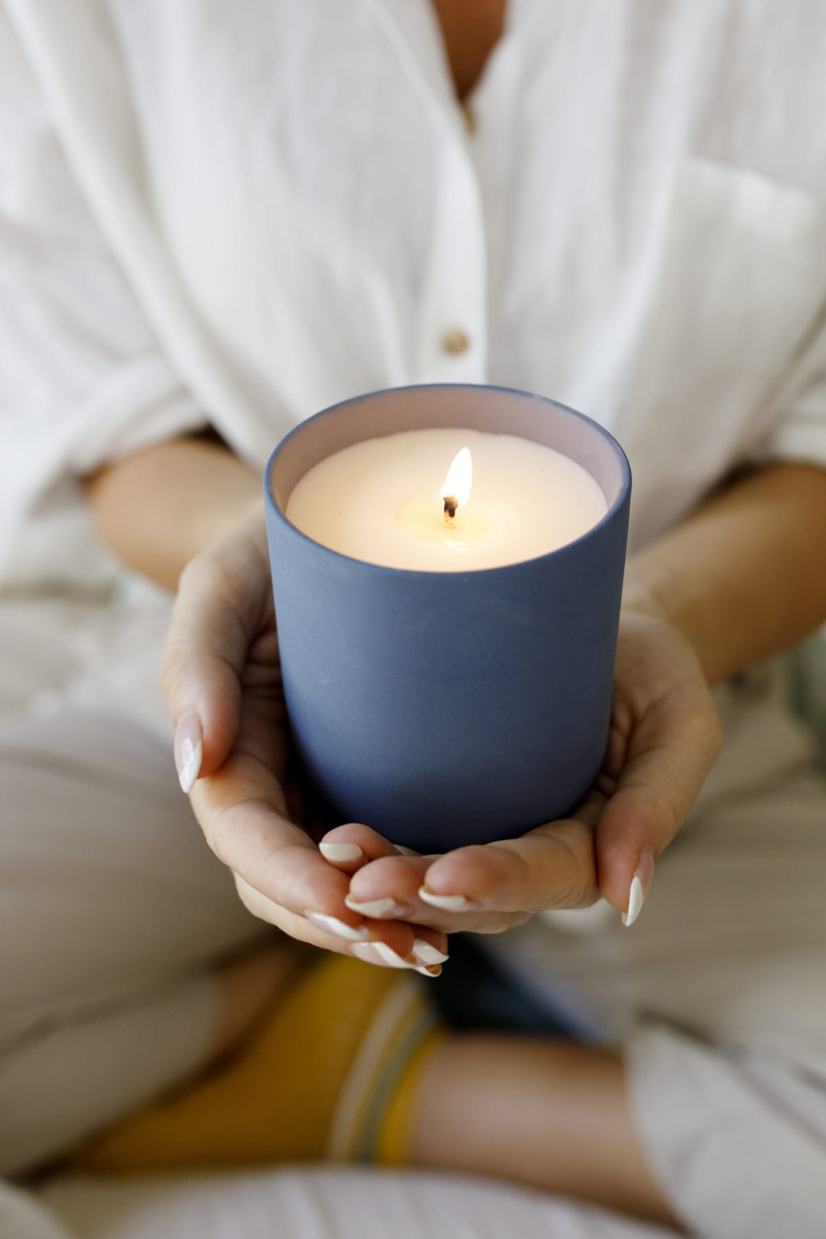 Woman holding a lit blue candle