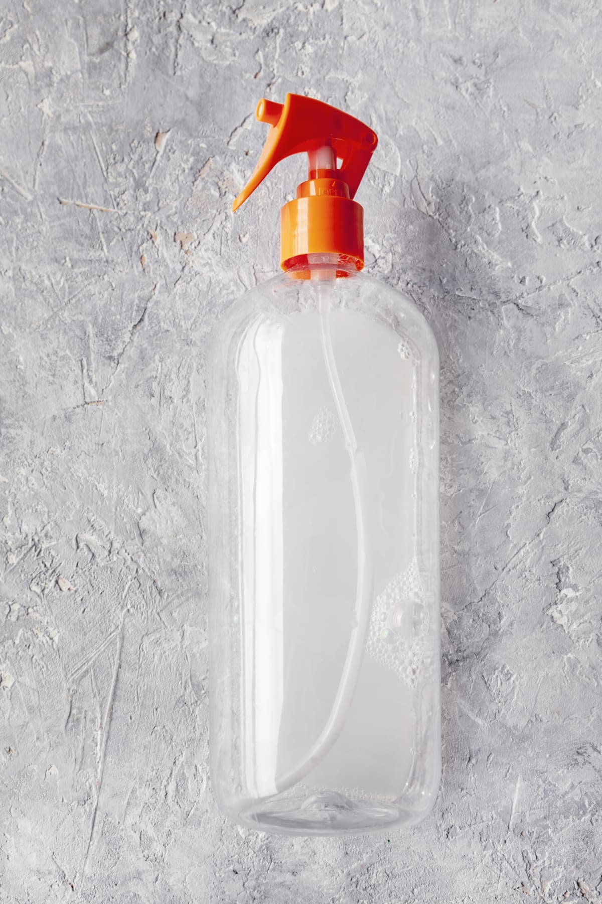 A spray bottle against a gray background