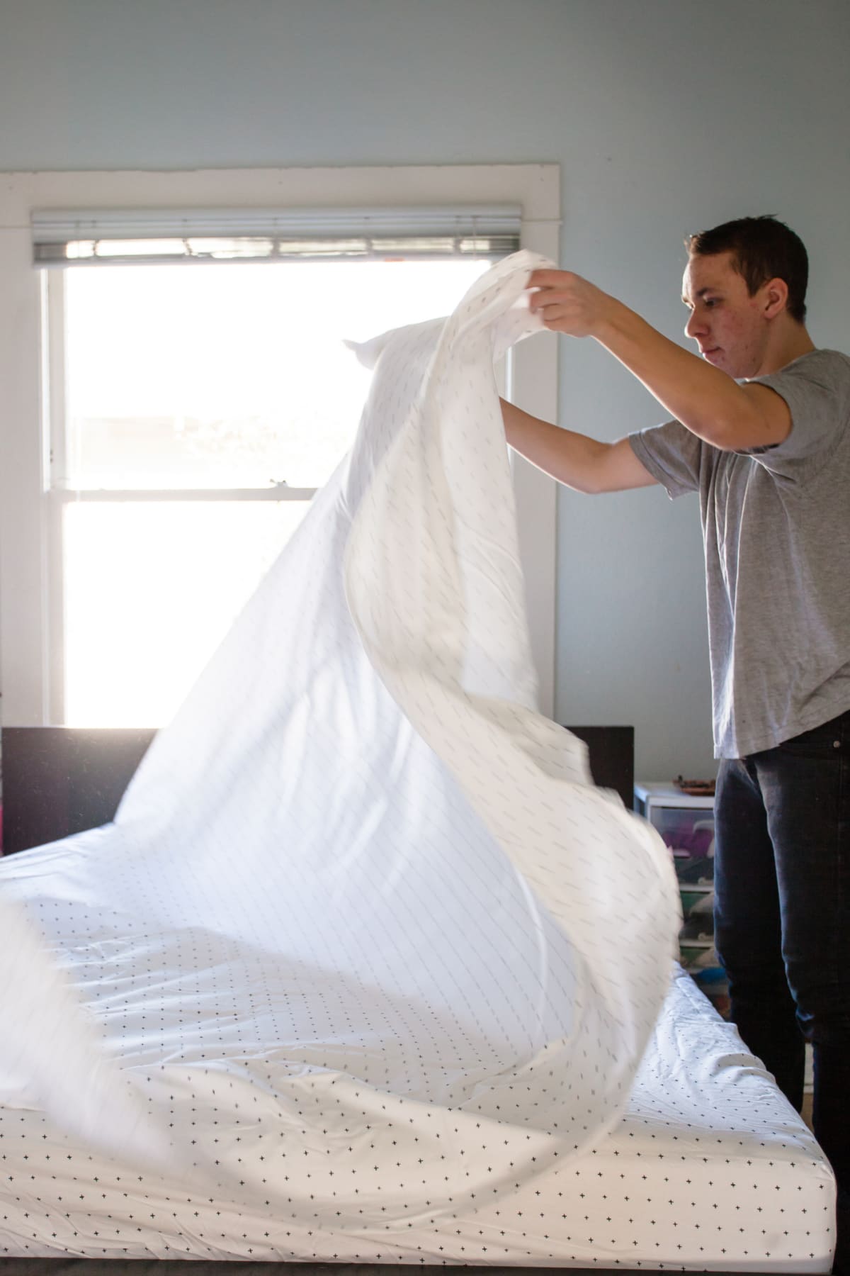 A man changing bedsheets