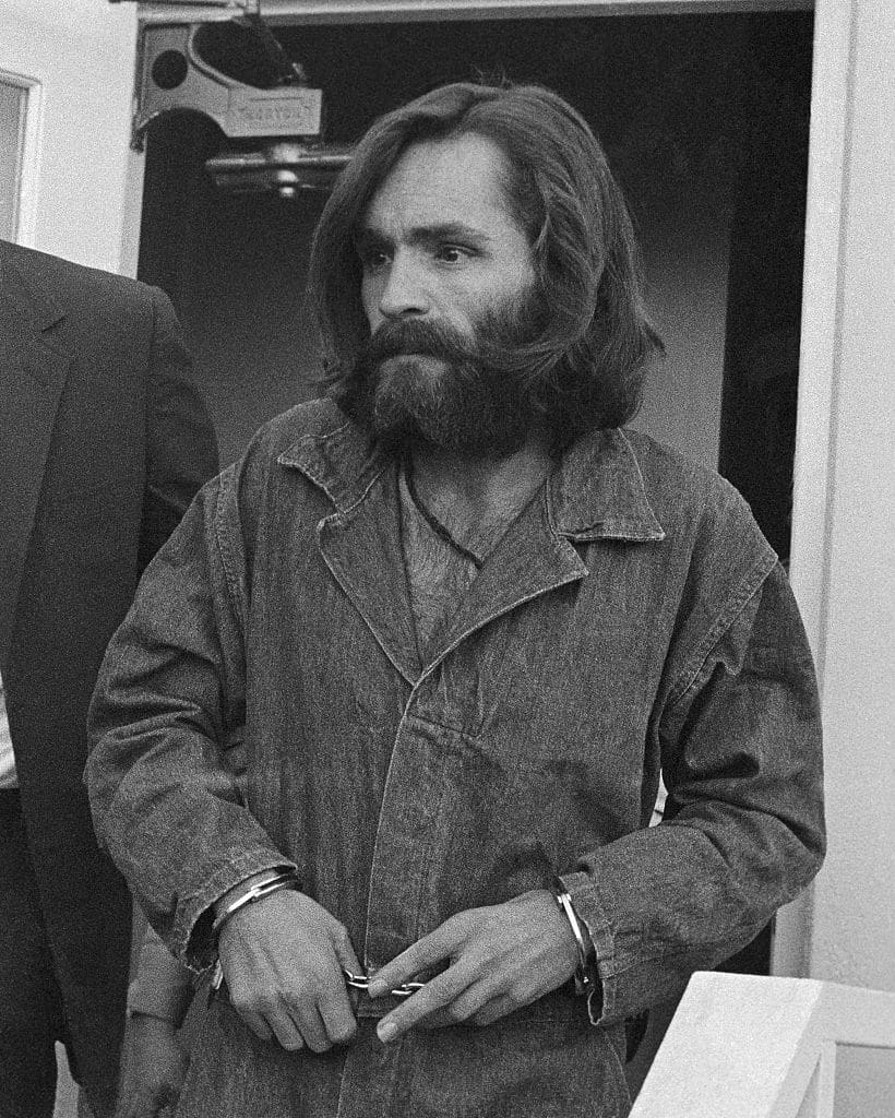 (Original Caption) Charles Manson, 34, arrives at the Inyo County Courthouse December 3rd for a preliminary hearing on charges of arson and receiving stolen goods. The leader of a quasi-religious hippie group and four of his followers have been indicted for the August 9th murders of actress Sharon Tate and four other persons.