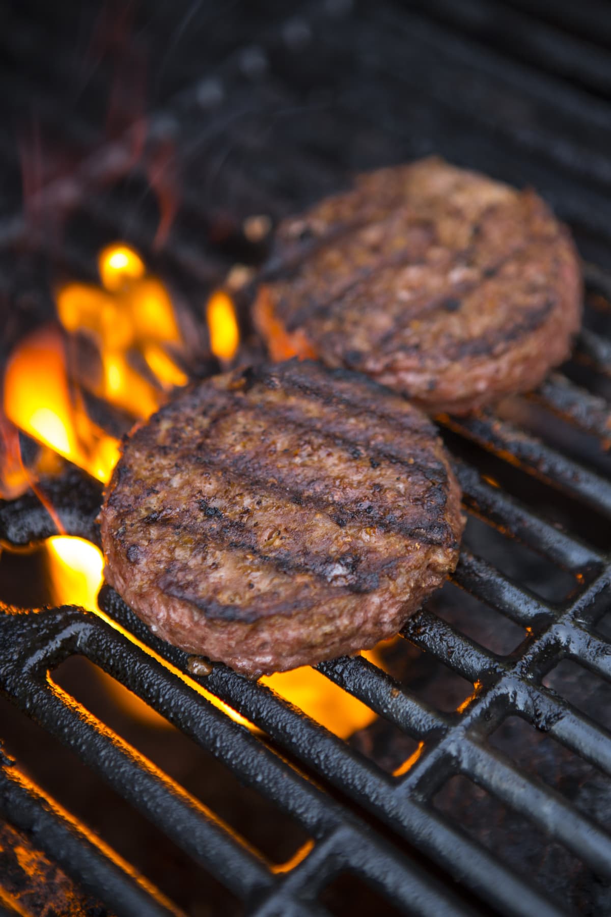 Two patties on grill above fire