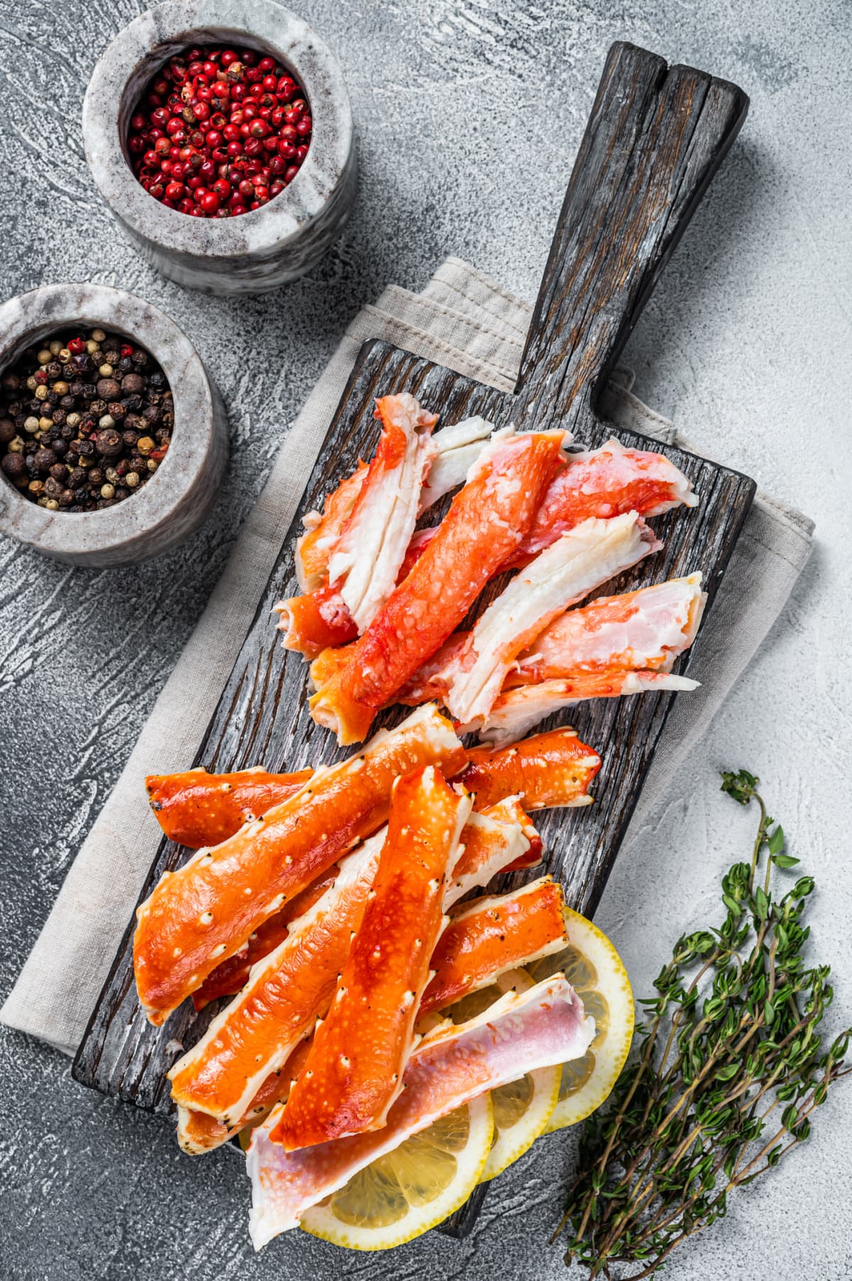 Cooked king crab leg meat on a wooden board with herbs