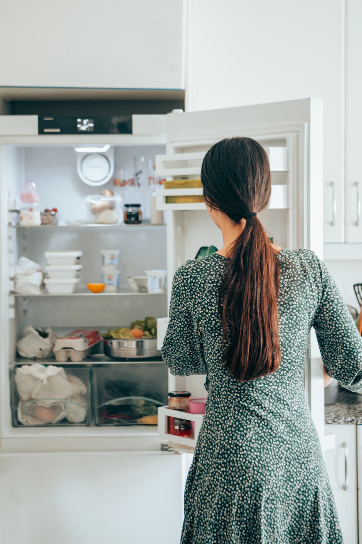 A woman looking inside her fridge