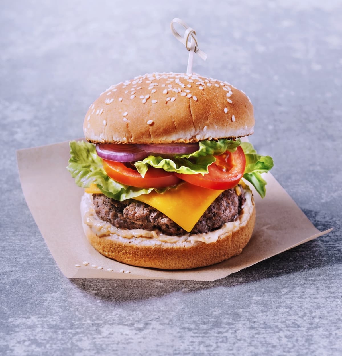 Burger on parchment paper on gray background