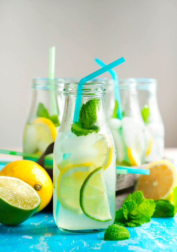 Glass bottle with lemonade and blue straw
