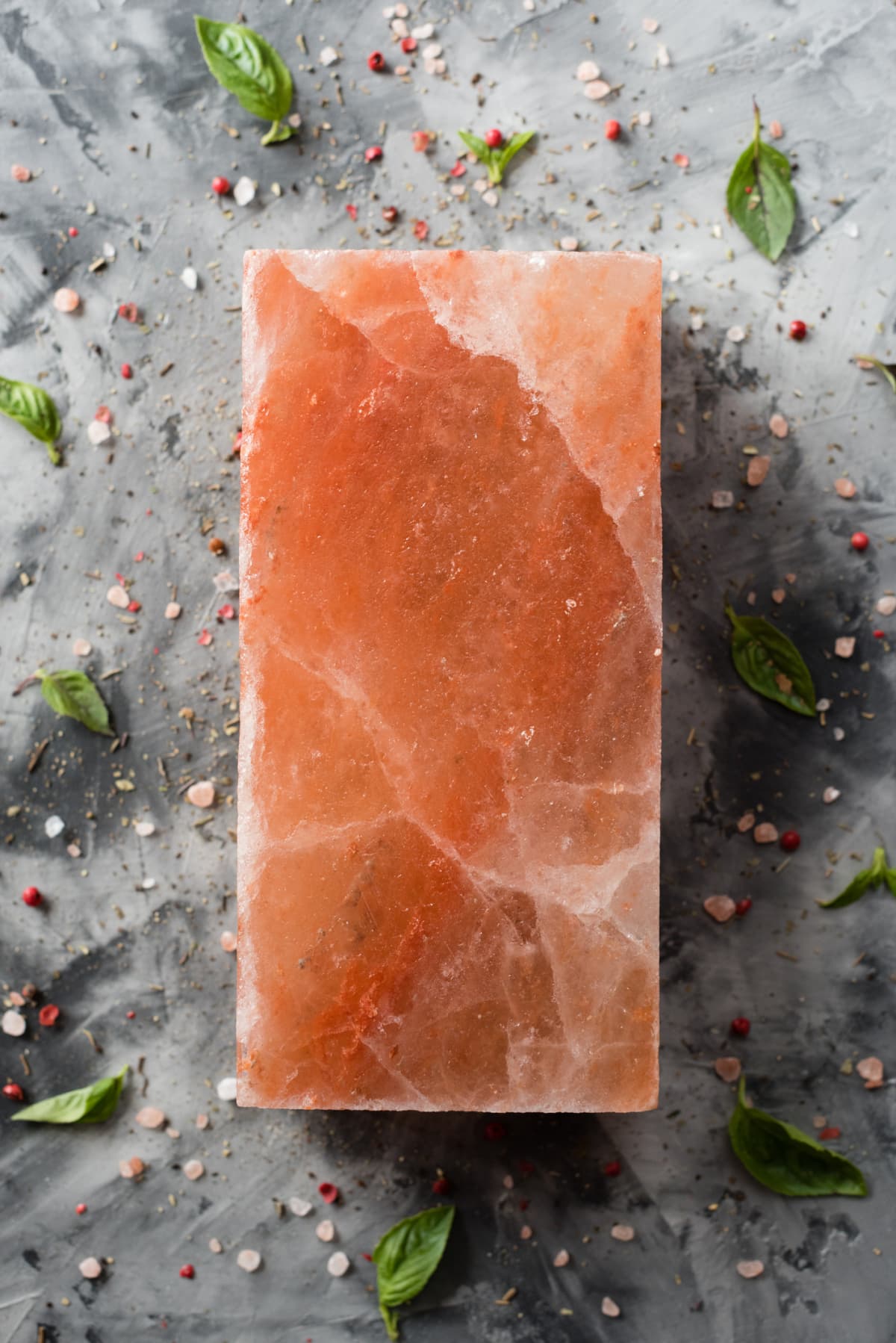 Himalayan pink salt block and spices on gray concrete background top view copy space