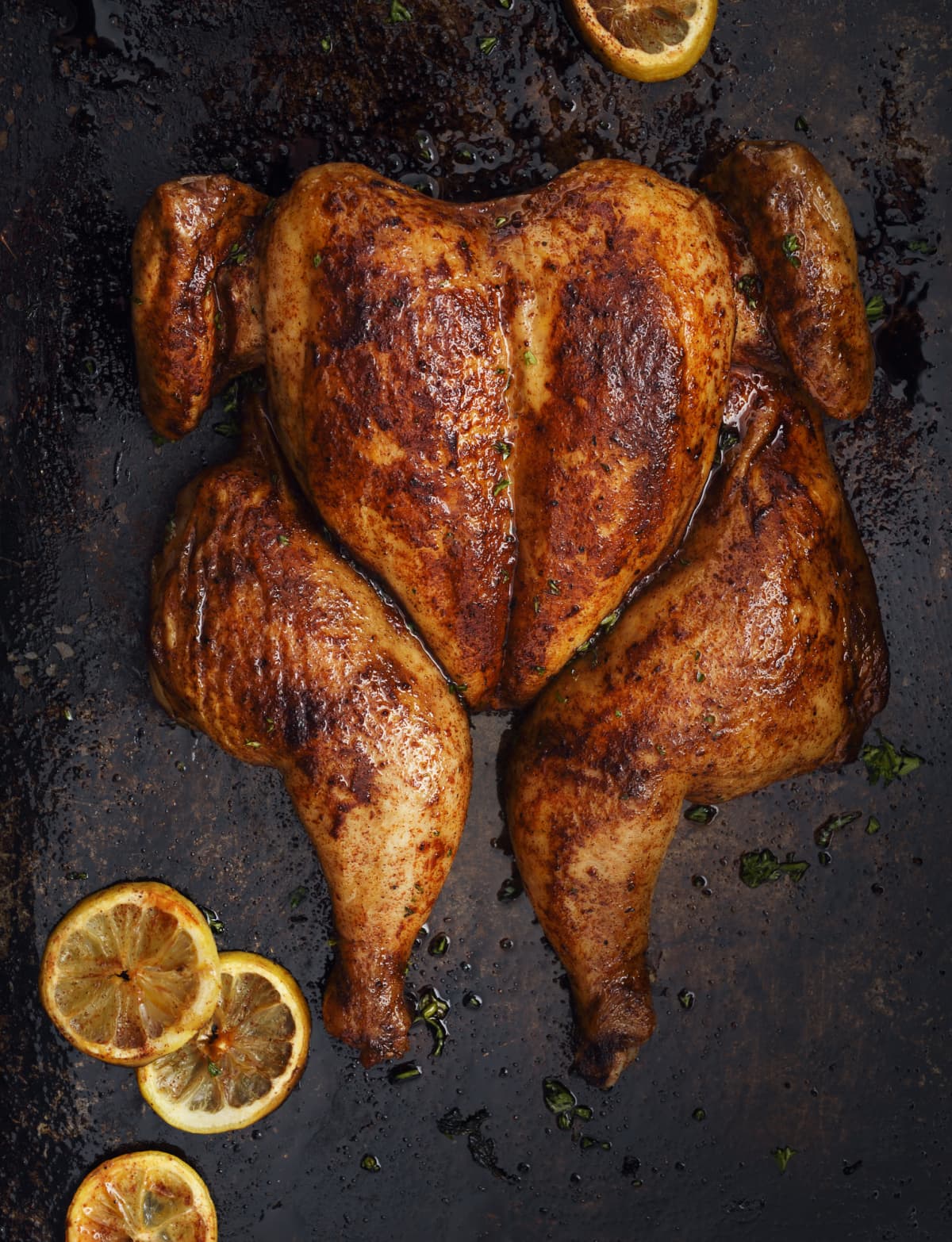 A roast chicken in a cooking pan