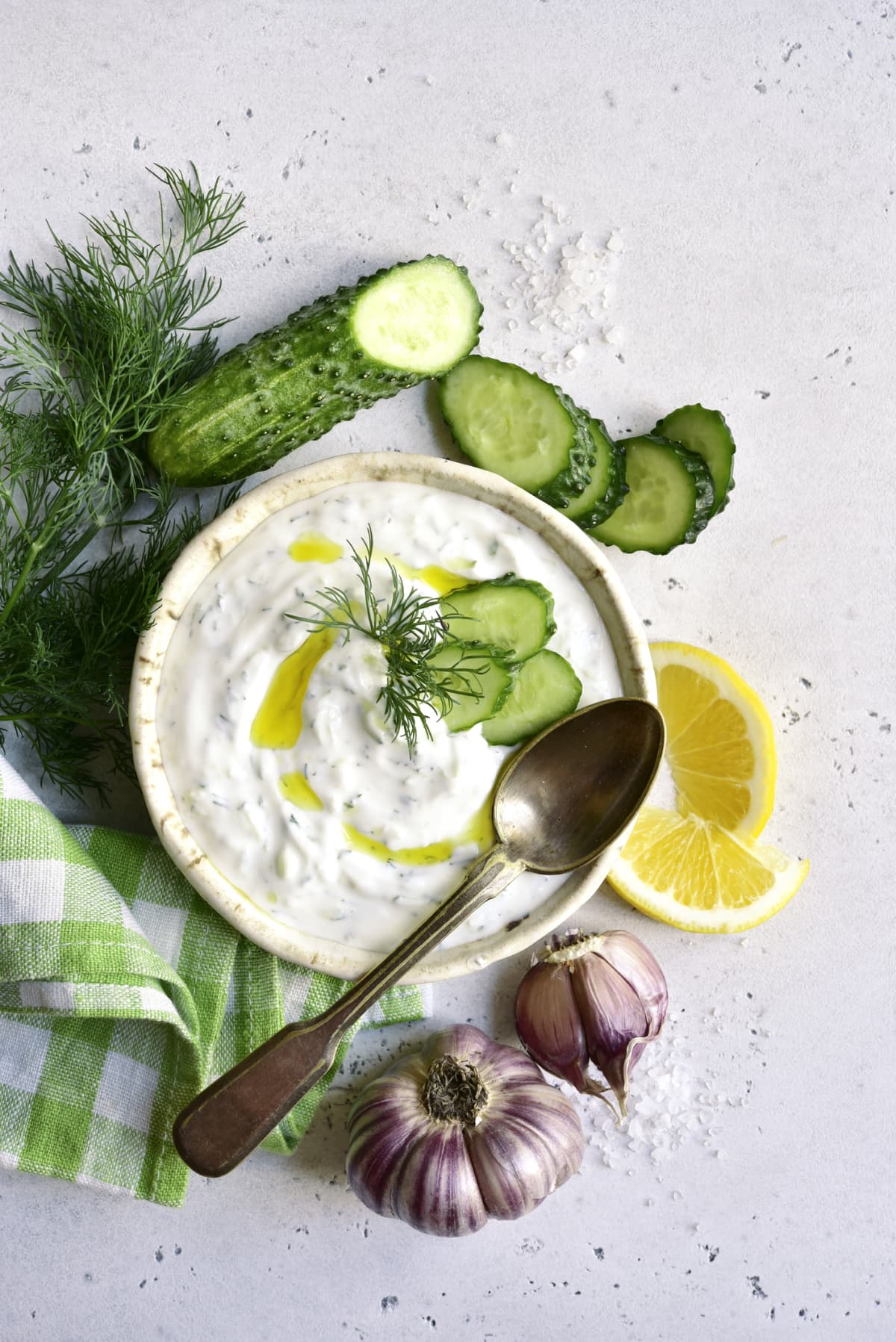 Tzatziki - traditional greek yogurt sauce in a bowl on a white slate, stone or concrete background. Top view with copy space.